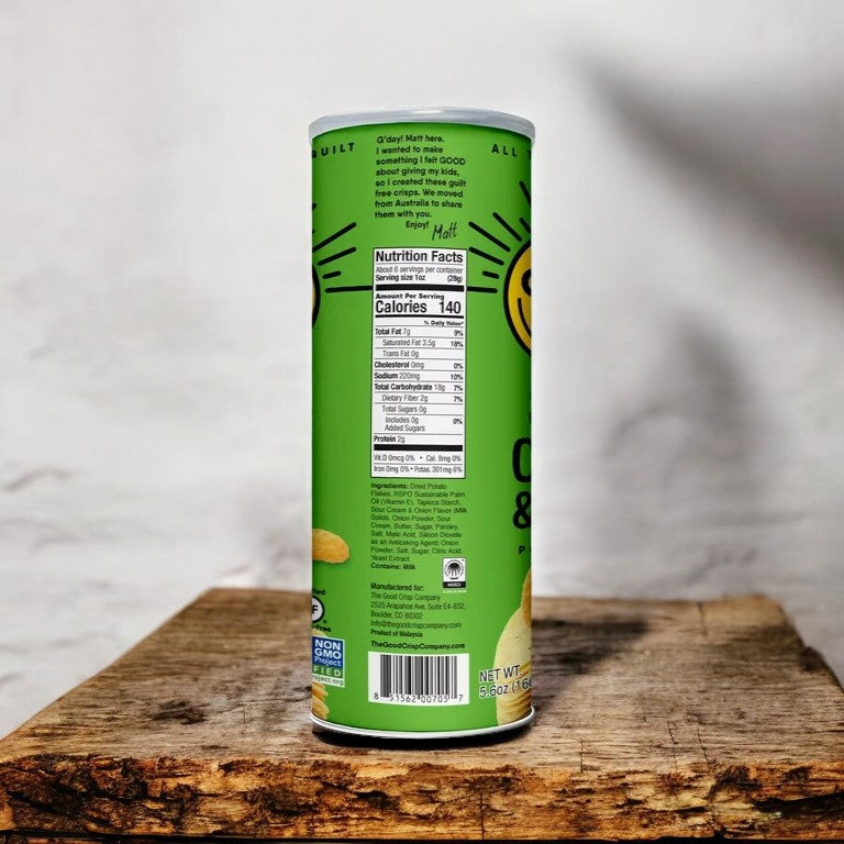 A 5.6 oz can of The Good Crisp Company Sour Cream and Onion potato snacks on a wooden surface. The can is upright, displaying the nutrition facts and ingredients label on the back.