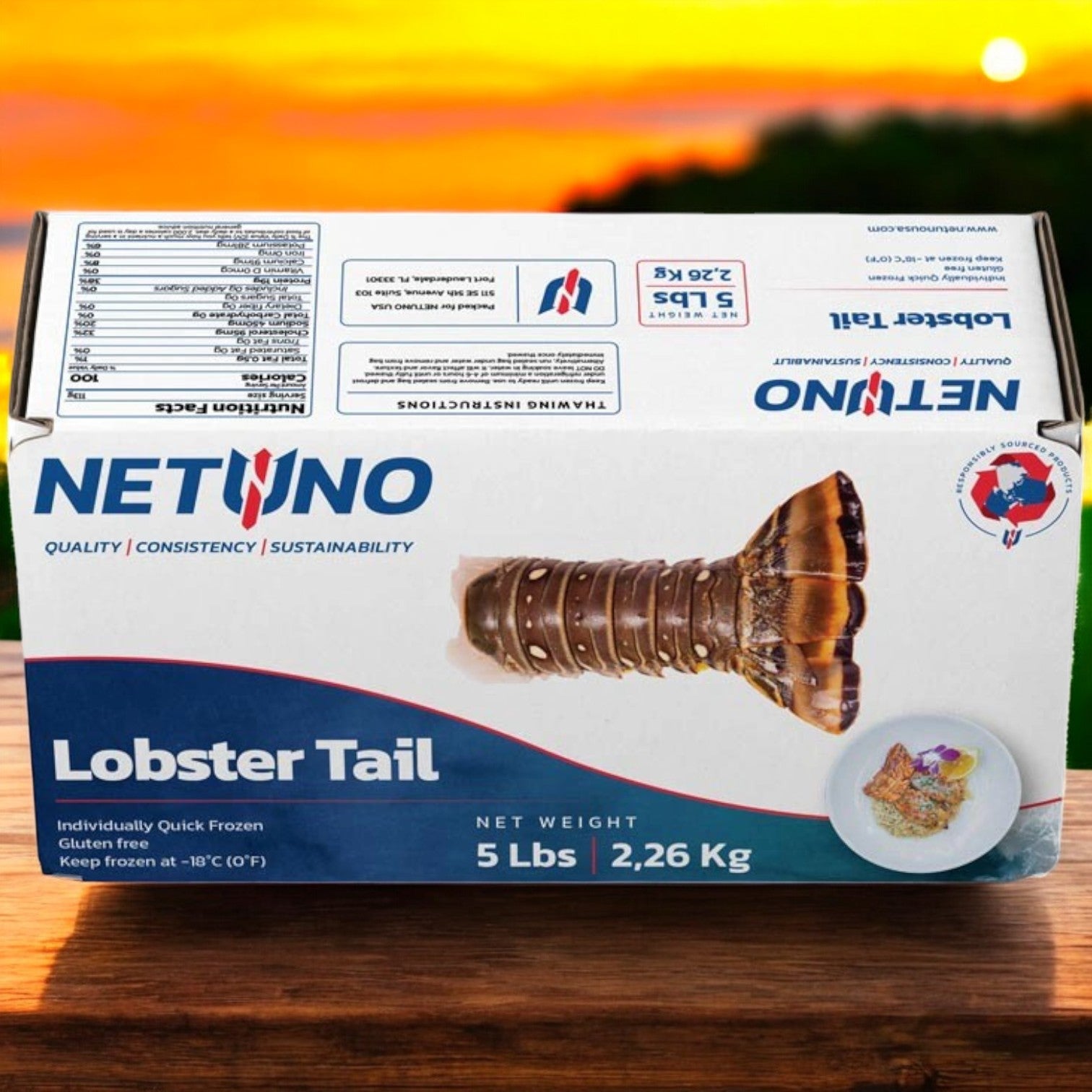 A box of Netuno Rock Lobster Tails sits on a wooden surface against a breathtaking sunset. The packaging highlights "5lb, 2.26 Kg" and underscores the exceptional quality and sustainability that enhance any gourmet dining experience.