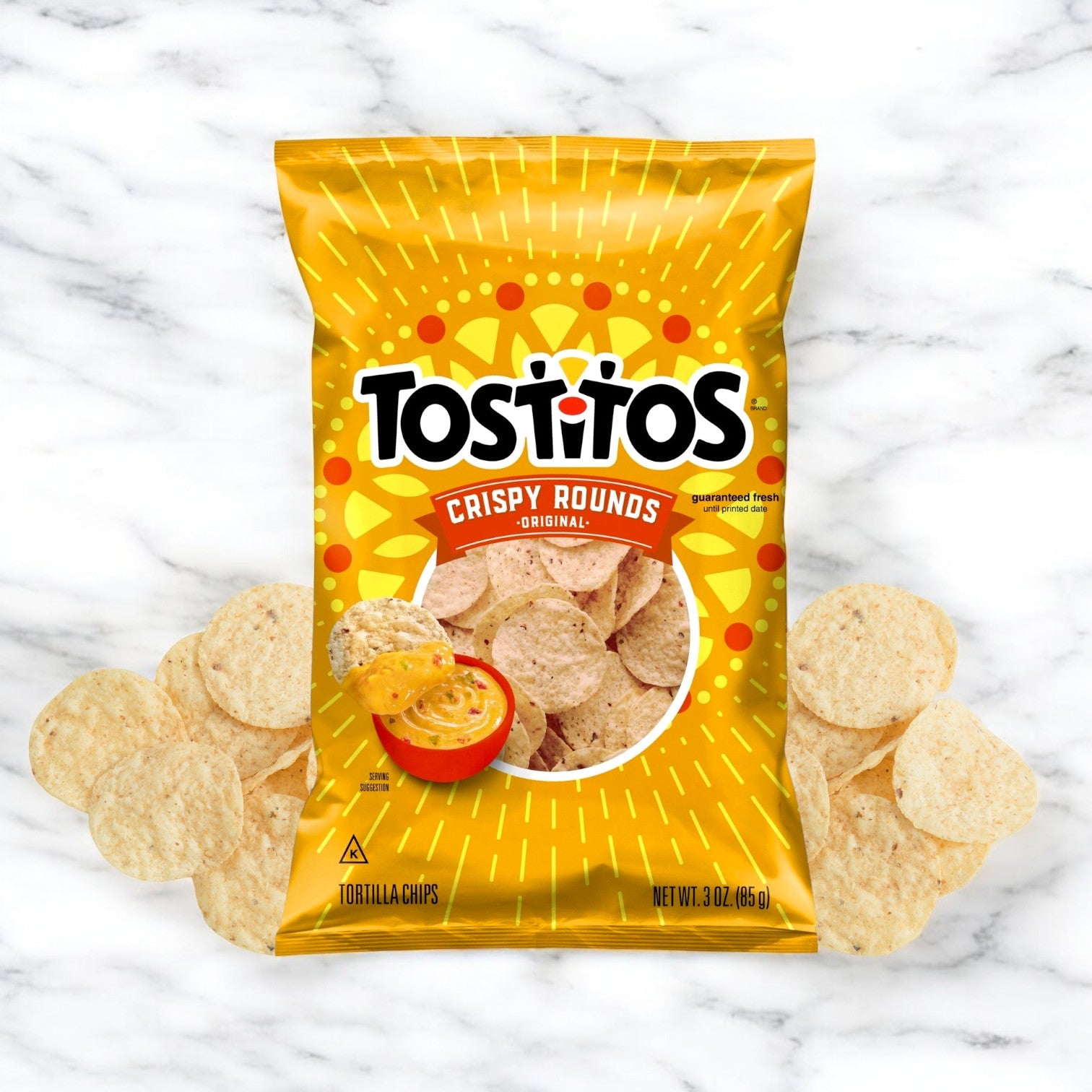 A few Tostitos Tortilla Chips, Round from a 28-Pack (3 oz each) are scattered on marble, perfect to pair with TOSTITOS Chunky Mild Salsa.