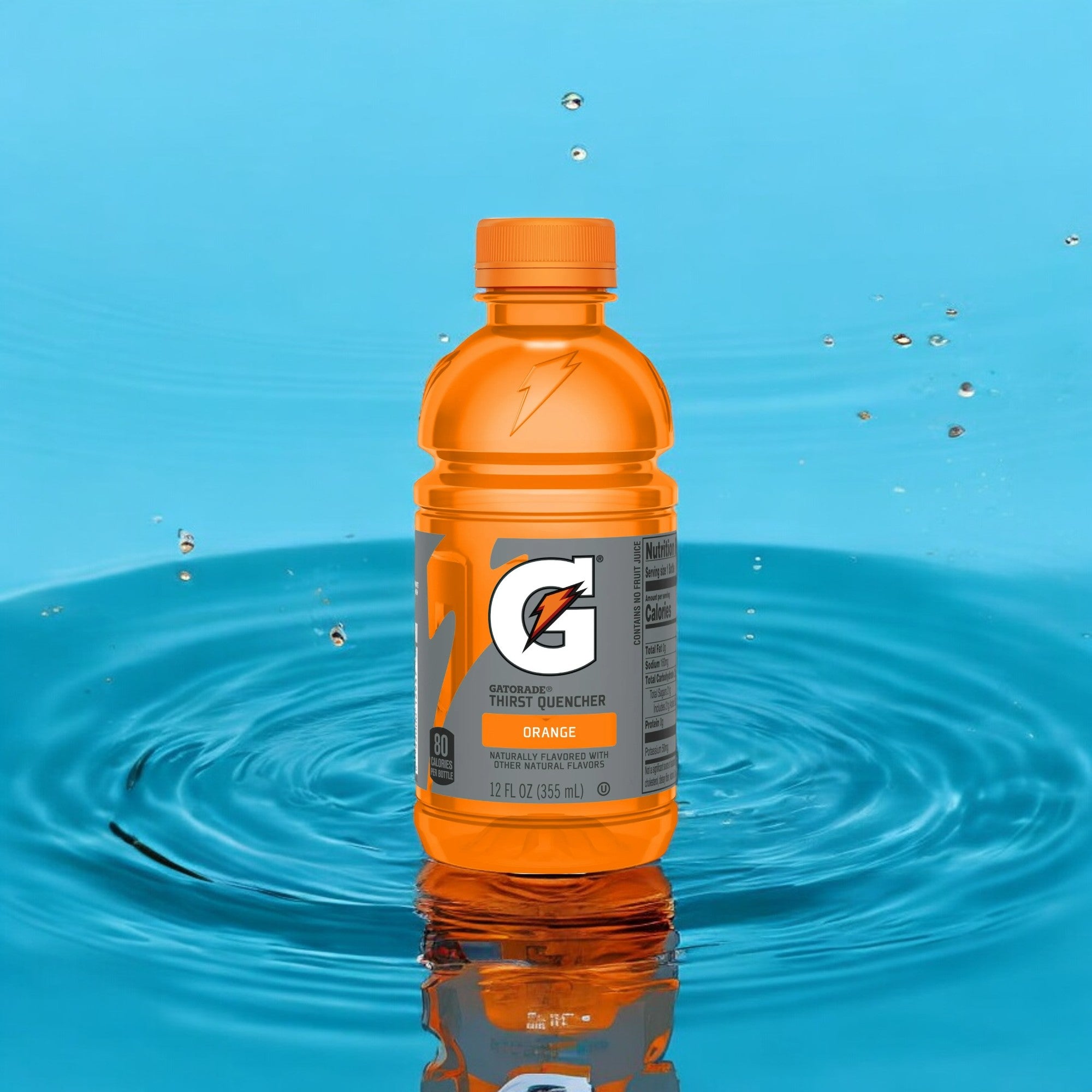 A bottle of Gatorade G Orange Thirst Quencher Sports Drink - Mini 12 oz - 1 Count stands upright against a backdrop of blue water with droplets and ripples, promising superior hydration and electrolyte replenishment.