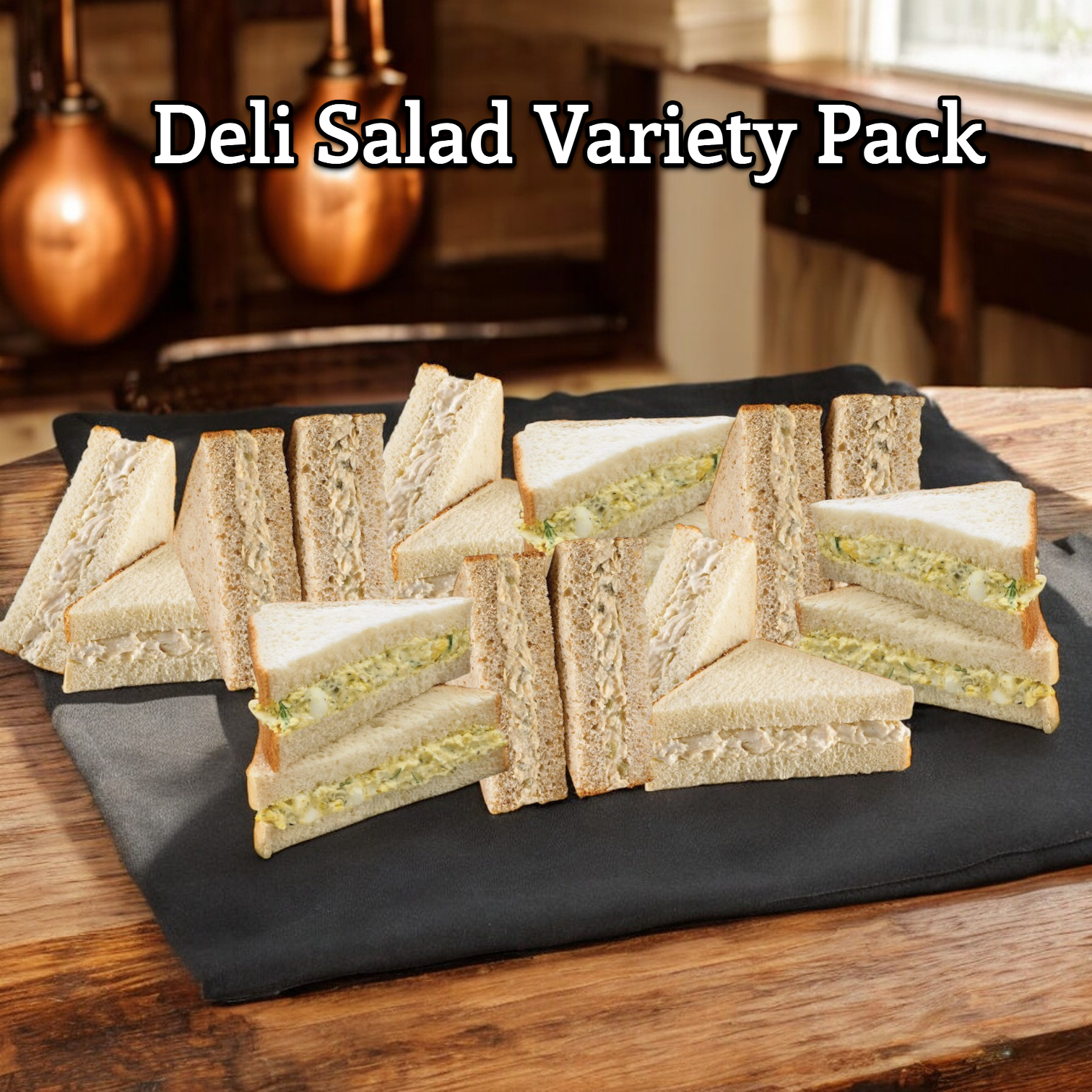 The E.A. Sween Deli Salad Variety Pack! features a delectable assortment of 3 Chicken Salad Sandwiches, 3 Dill Egg Salad Sandwiches, and 3 Albacore Tuna Salad Sandwiches, beautifully presented as sandwich wedges on whole-grain bread. These savory selections are displayed on a black cloth atop a wooden surface. Text at the top reads "Deli Salad Variety Pack! 9 Total Items!