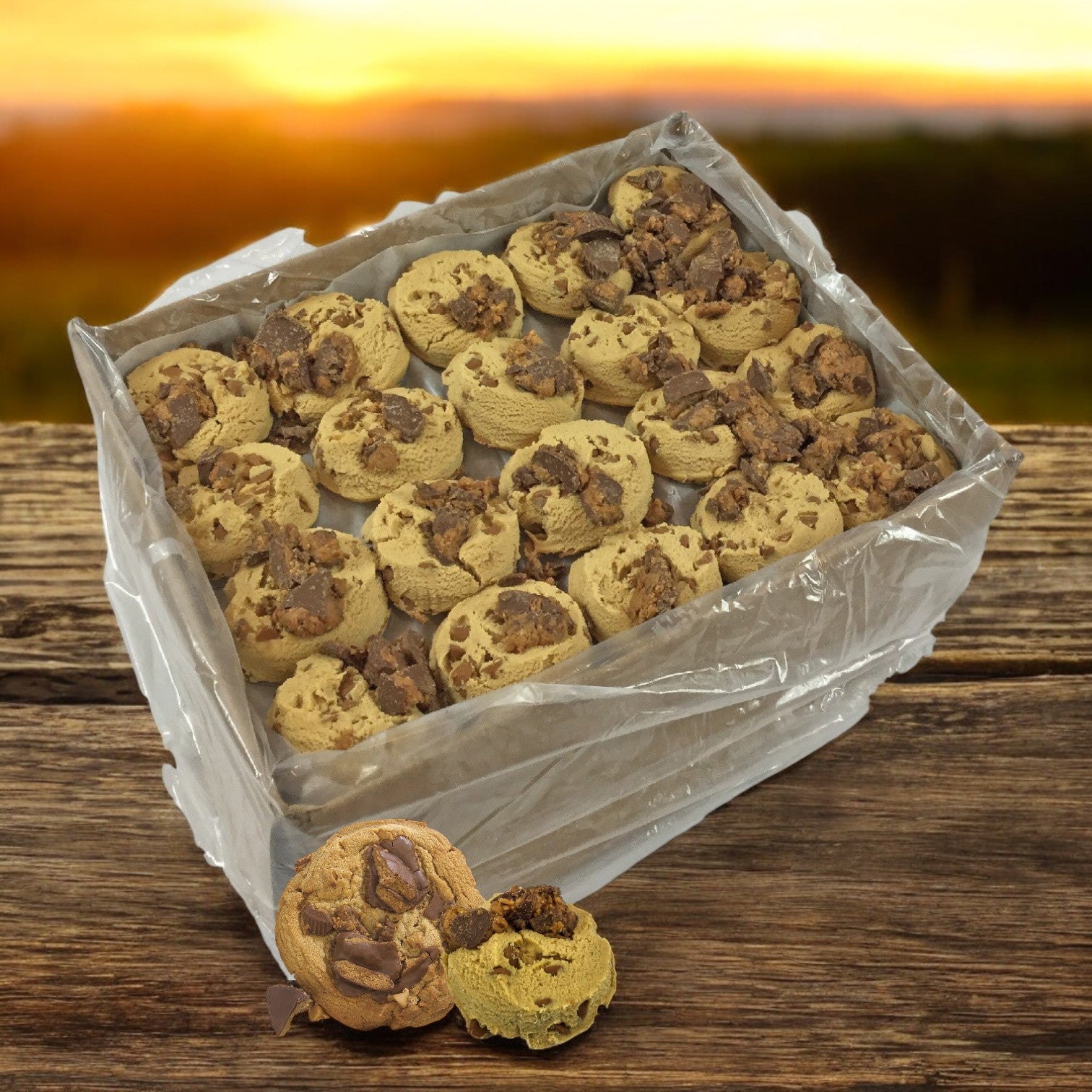 David's Cookies Reese's Peanut Butter Chunk Dough box with round, rich-chocolate cookies on wood against a sunset backdrop.