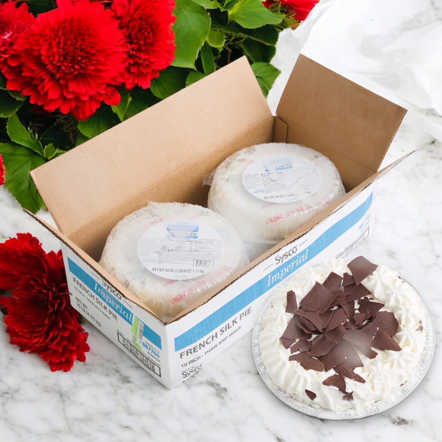 A box of Imperial Fresh Pie French Silk Pie Thaw & Serve 10" 4/40 oz is next to a sliced pie on a marble surface, with red flowers in the background.