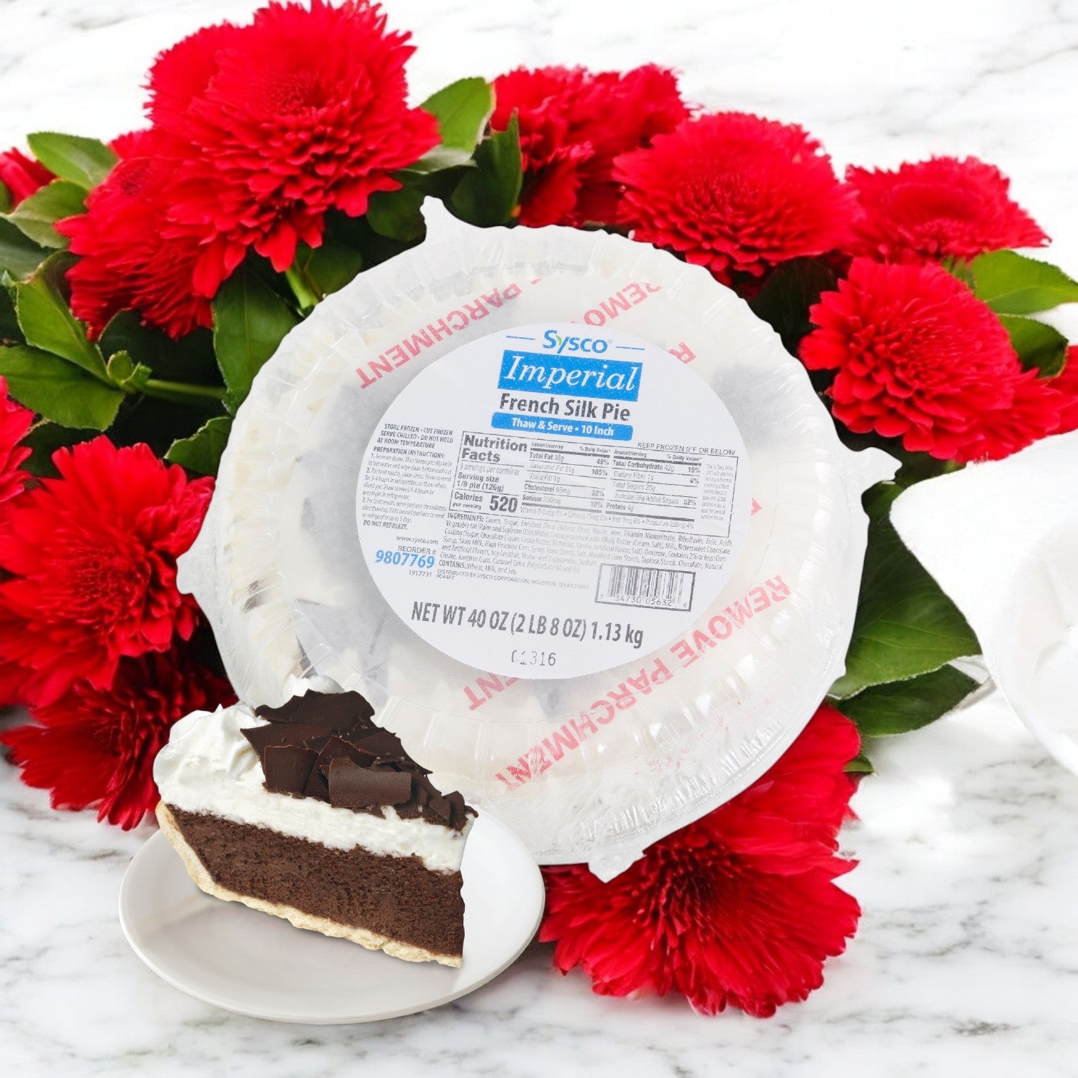 A delectable 10" French Silk Pie by Imperial Fresh sits in a white container, partially served on a plate. This luscious chocolate dessert is surrounded by vibrant red flowers, making it visually inviting and delicious—a true delight for any Thaw & Serve occasion.