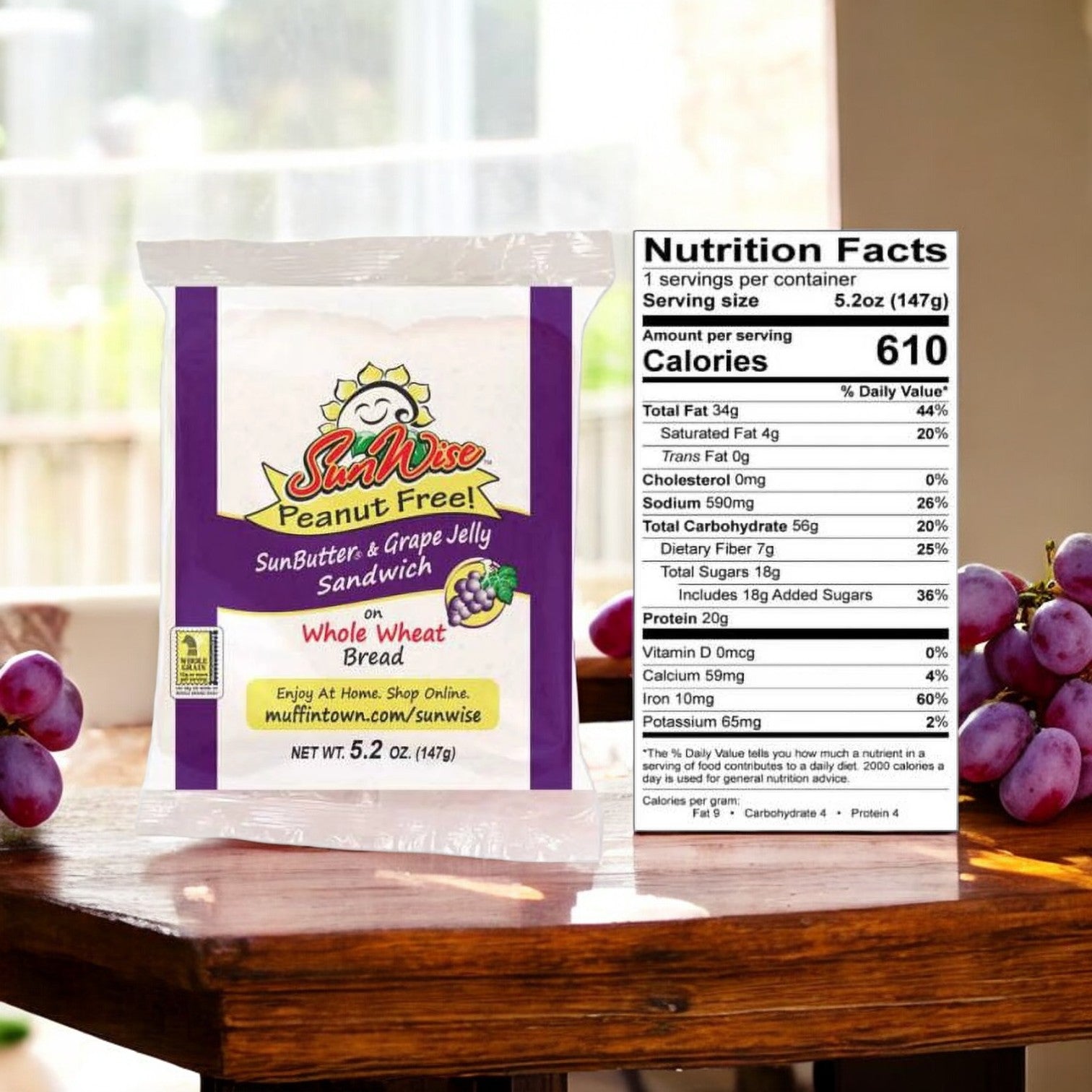 Here's an image of a SunWise Grape Jelly by Easy Lunches, featuring a peanut-free SunButter & grape jelly sandwich in a single-serving 2.8 oz container, placed on a wooden surface with grapes in the background. The nutrition facts are displayed beside the sandwich.