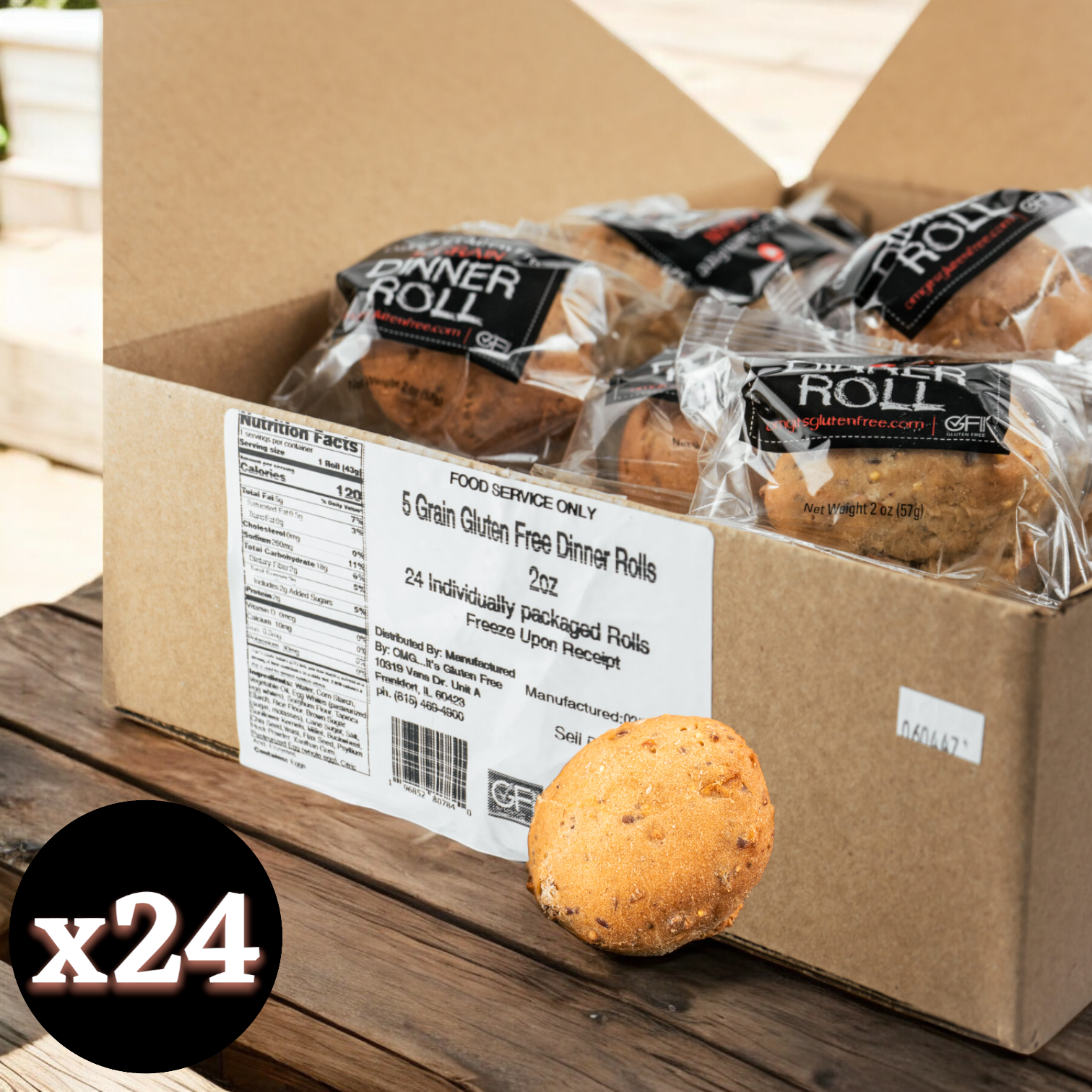 A cardboard box labeled "OMG It's Gluten Free, 5 Grain Dinner Roll, 2 oz. - 1 Case, 24 Pack" containing 24 individually packaged gluten-free dinner rolls, with one roll displayed in front of the box. The packaging showcases product and nutrition information, emphasizing the nutritious grains for versatile use.