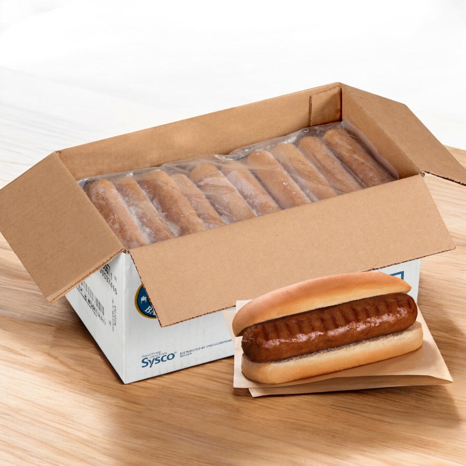 A cardboard box holds packaged hot dog buns while the Sysco Block & Barrel Imperial by Sysco Bratwurst Cooked Beer Craft 4x1 (2/5 LB) offers a gourmet delight.