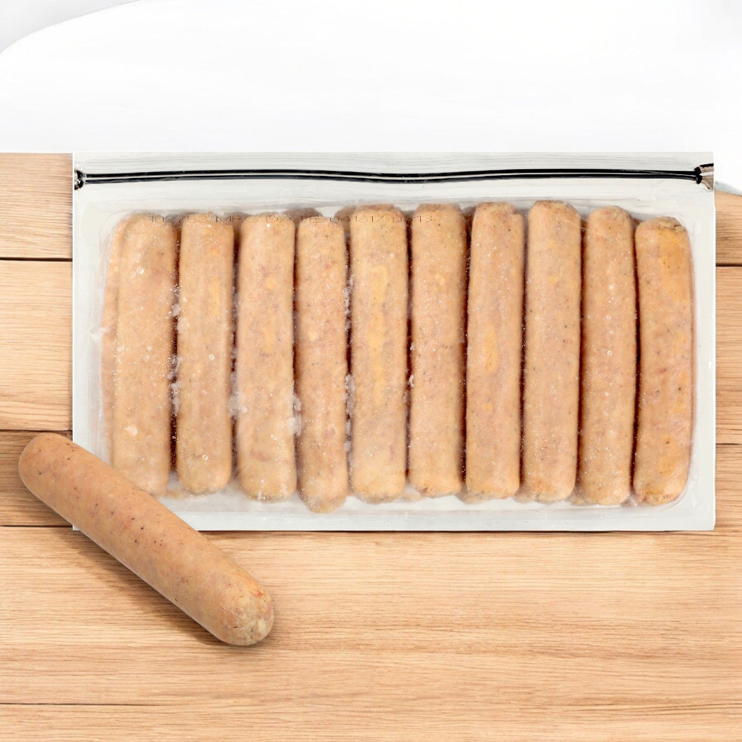 A sealed package of Block & Barrel Imperial by Sysco Bratwurst Cooked Beer Craft sausages arranged in a row, with one premium pre-cooked bratwurst on a wooden surface.