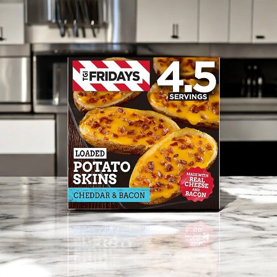 A TGIF Fridays Loaded Cheddar & Bacon Potato Skins Value Size Frozen Snack box rests invitingly on a marble countertop against a cozy kitchen backdrop.