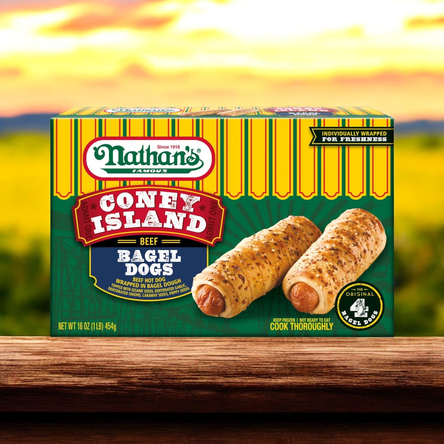 A Nathan’s Famous Coney Island Bagel Dogs – 20 oz box rests on a wooden surface, highlighting its appealing product image and branding against a rustic countryside backdrop.