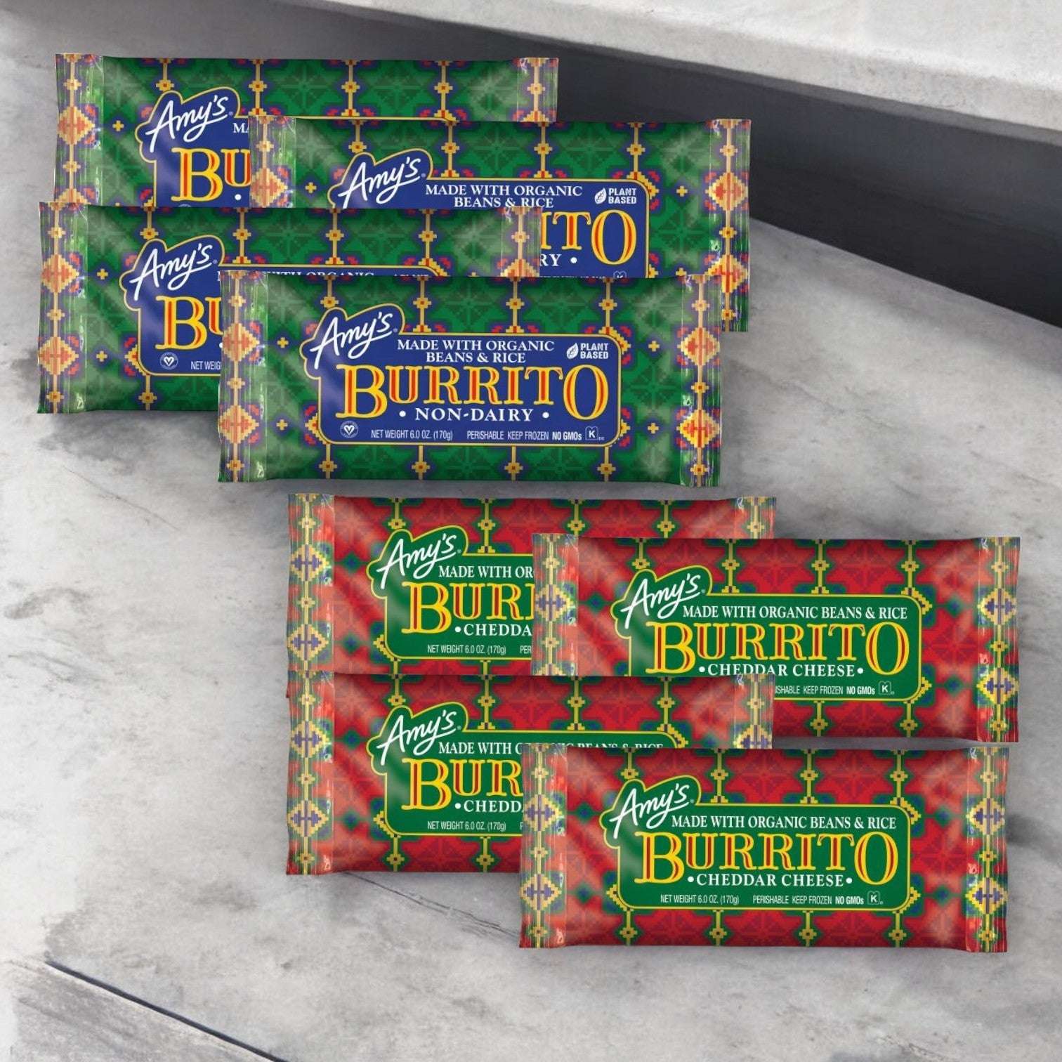 A stack of Amy's Burritos packages in green and red wrappers displayed on a countertop. The burritos are labeled as Amy's Vegan Bean & Rice or Amy's Bean & Cheese, totaling 8 burritos.