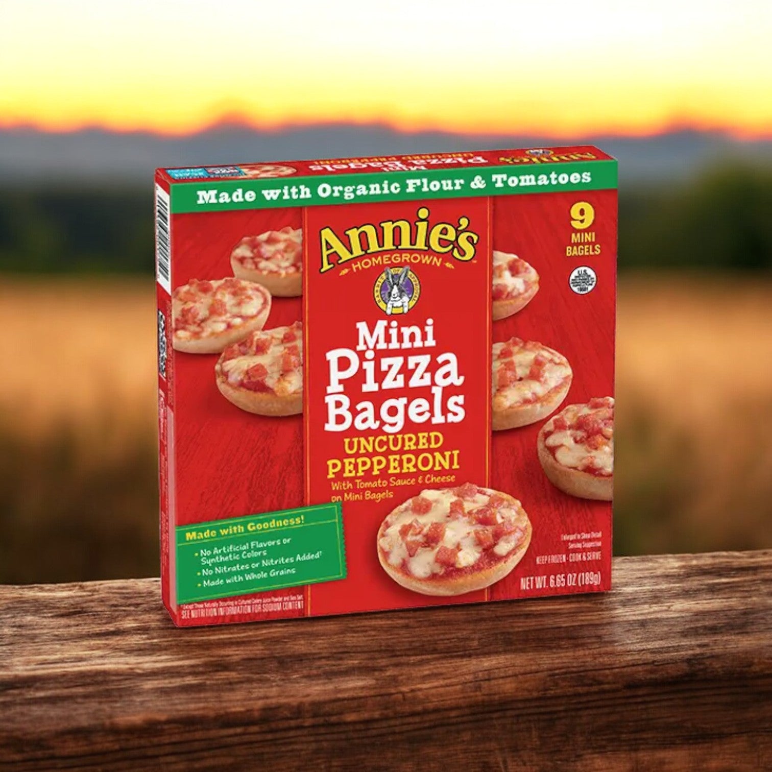 A box of Annie's Uncured Pepperoni Mini Pizza Bagels, weighing 6.65 oz., is displayed outside, highlighting its real cheese and organic ingredients. Inside, you'll discover nine tasty mini bagels that are ready to enjoy.