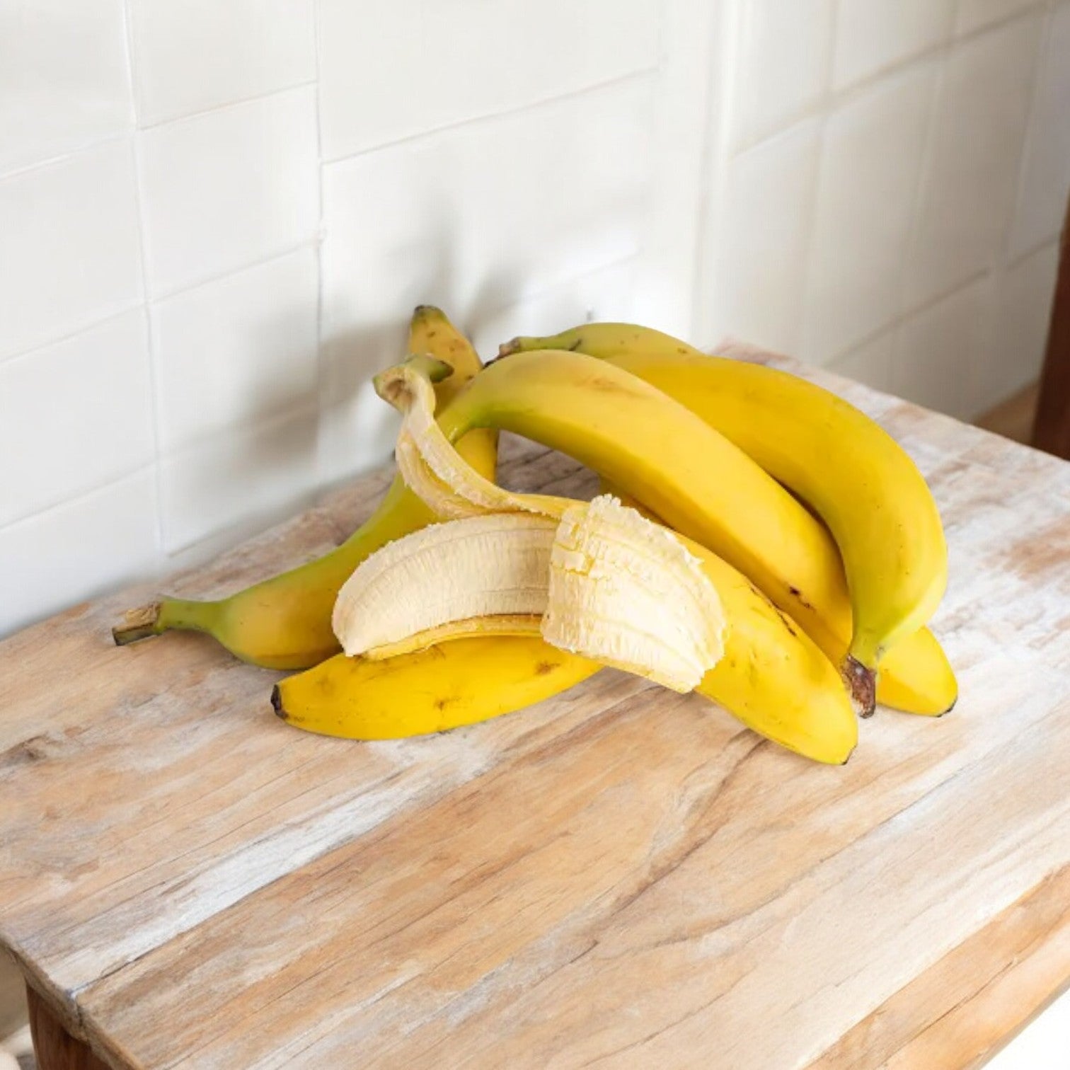 A bunch of Easy Lunches Bananas 4 lbs on a wooden surface, with one banana partially peeled.