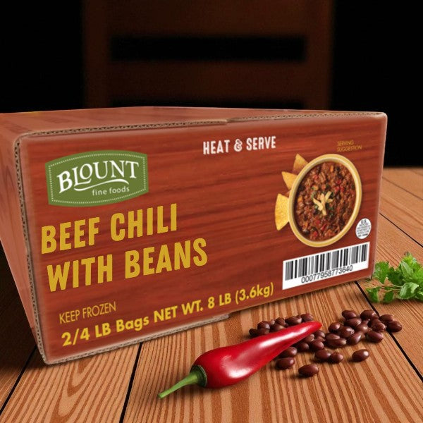 A box of Blount Fine Foods' Frozen Beef Chili with Beans (2 packs, 4 lbs each) sits on a table by a red chili pepper and kidney beans, highlighting this hearty, savory chili that's fully cooked and ready to heat and serve.