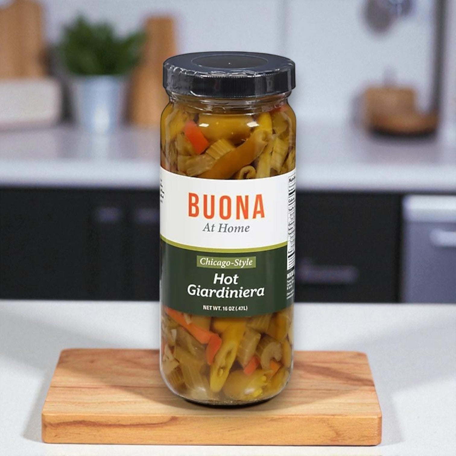 A jar of Buona Giardiniera, Hot, Chicago Style – 16 oz sits on a small wooden cutting board next to mild Italian sausage in a modern kitchen.