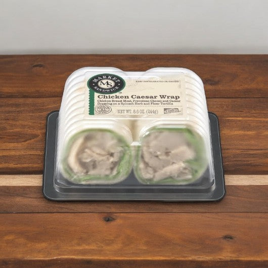 The E.A. Sween Chicken Caesar Wrap, a pre-packaged delight featuring savory Parmesan cheese and creamy Caesar dressing, weighs 8.6 oz and is displayed on a wooden surface.