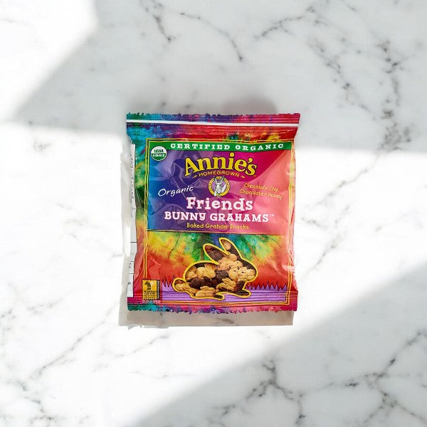 A package of Annie's Organic Friends Bunny Grahams- 1 Count, USDA Organic treats by Annie's in a colorful bag, sits on a marble surface.