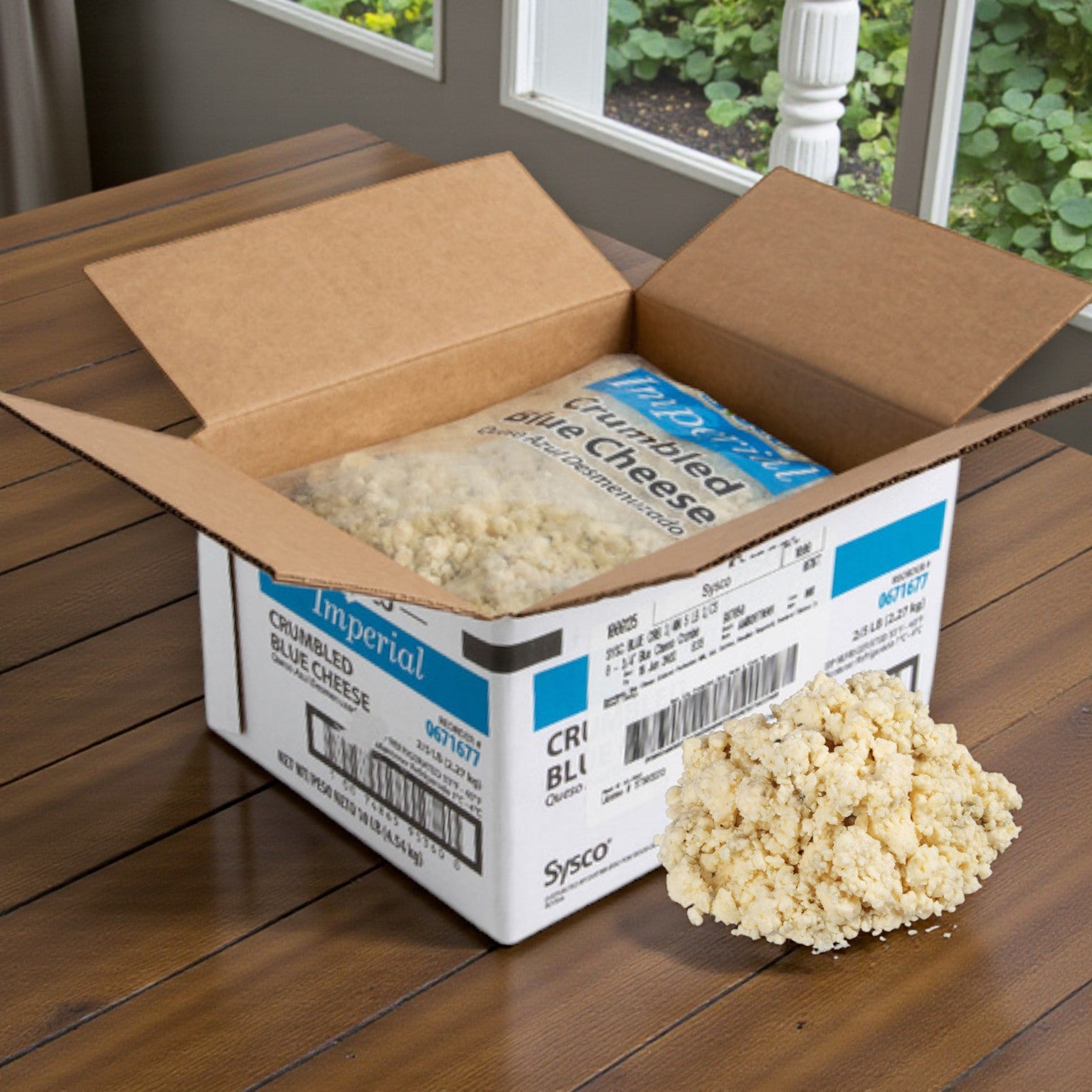 A Sysco Imperial Blue Cheese Crumbles (2/5 lb) box sits open on a table, showing premium blue cheese crumbles in a plastic bag with some spilled nearby—ideal for foodservice kitchens.