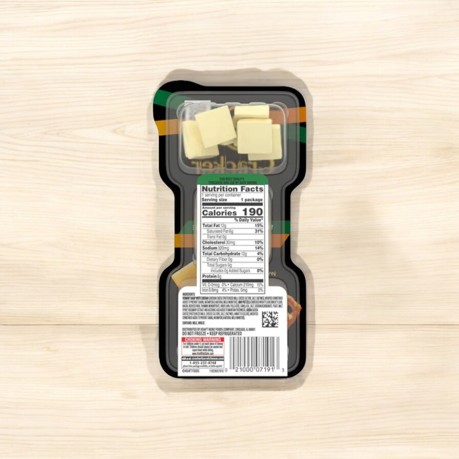 A packaged snack tray of Easy Lunches Cracker Barrel Bites with Vermont Sharp White Cheddar and Gouda Cheese, accompanied by pretzel chips, displayed on a light wooden surface, featuring nutritional facts on the back.