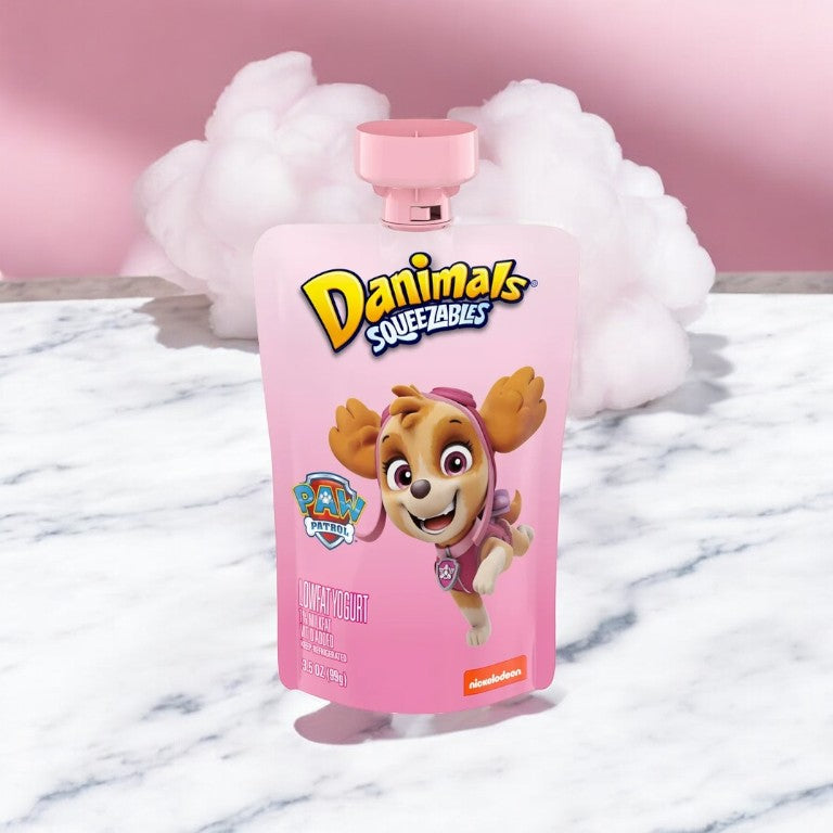 A pouch of Danimals Cotton Candy Squeezable Yogurt by Easy Lunches, weighing 3.5 oz and featuring a PAW Patrol character on the packaging, is displayed on a marble surface, making it a nutritious snack in a convenient squeezable format.