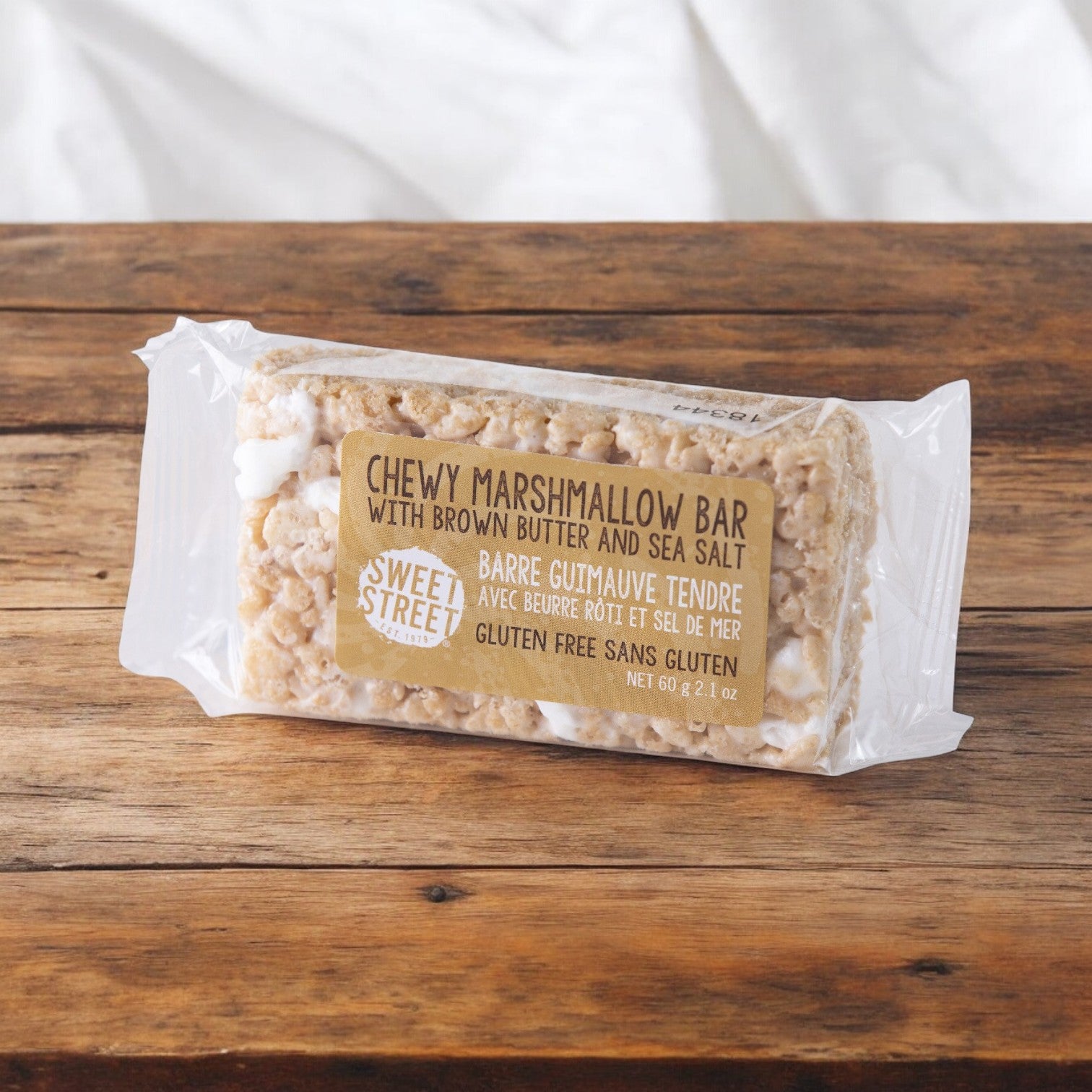 Sweet Street Dessert Bar Marshmallow, 2.1 oz., is individually wrapped for freshness and features a chewy marshmallow base with brown butter notes and a hint of sea salt, elegantly displayed on a wooden surface. Each case contains 40 bars.