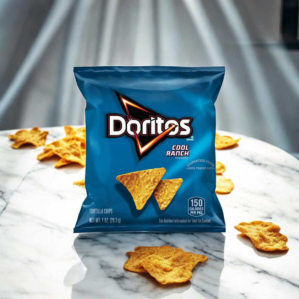 A single-serving Frito Lay Doritos Cool Ranch Flavored Tortilla Chips, 1 oz bag rests on a marble surface, perfect for on-the-go snacking among scattered tortilla chips. The bag, which contains 150 calories per serving, stands prominently showcasing its nutritional information.