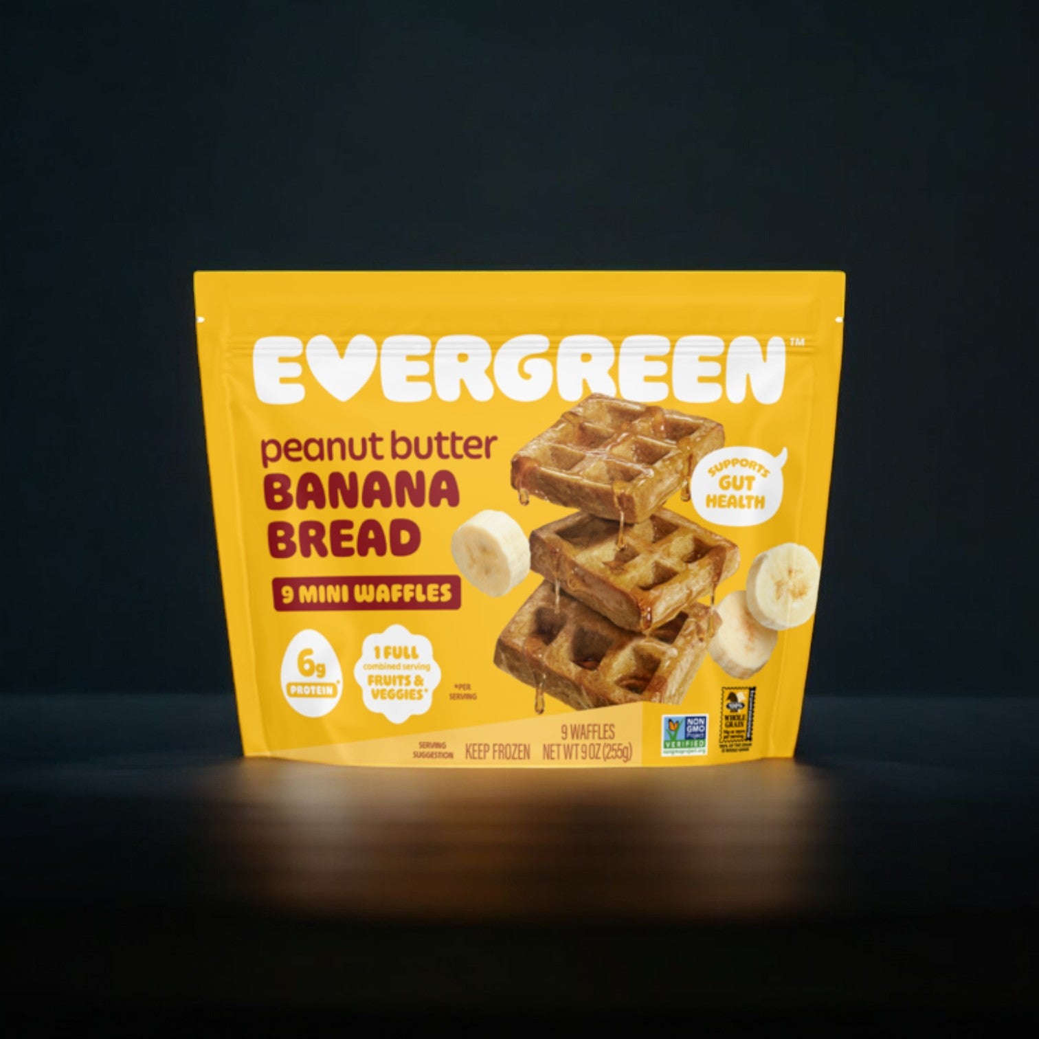 The Evergreen Peanut Butter Banana Bread, Frozen Mini Waffles, 9 oz. - 1 Count, showcase a yellow label adorned with images of waffles and banana slices, emphasizing the authentic ingredients used in these frozen mini waffles.