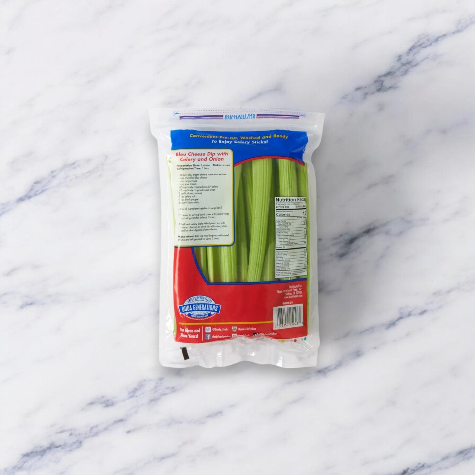 A bag of Fresh Celery Sticks from Easy Lunches is showcased on a white marble surface. The 20 oz low-calorie snack comes in packaging with a vibrant blue and red design, featuring prominent nutritional information and the Easy Lunches logo displayed on the front.