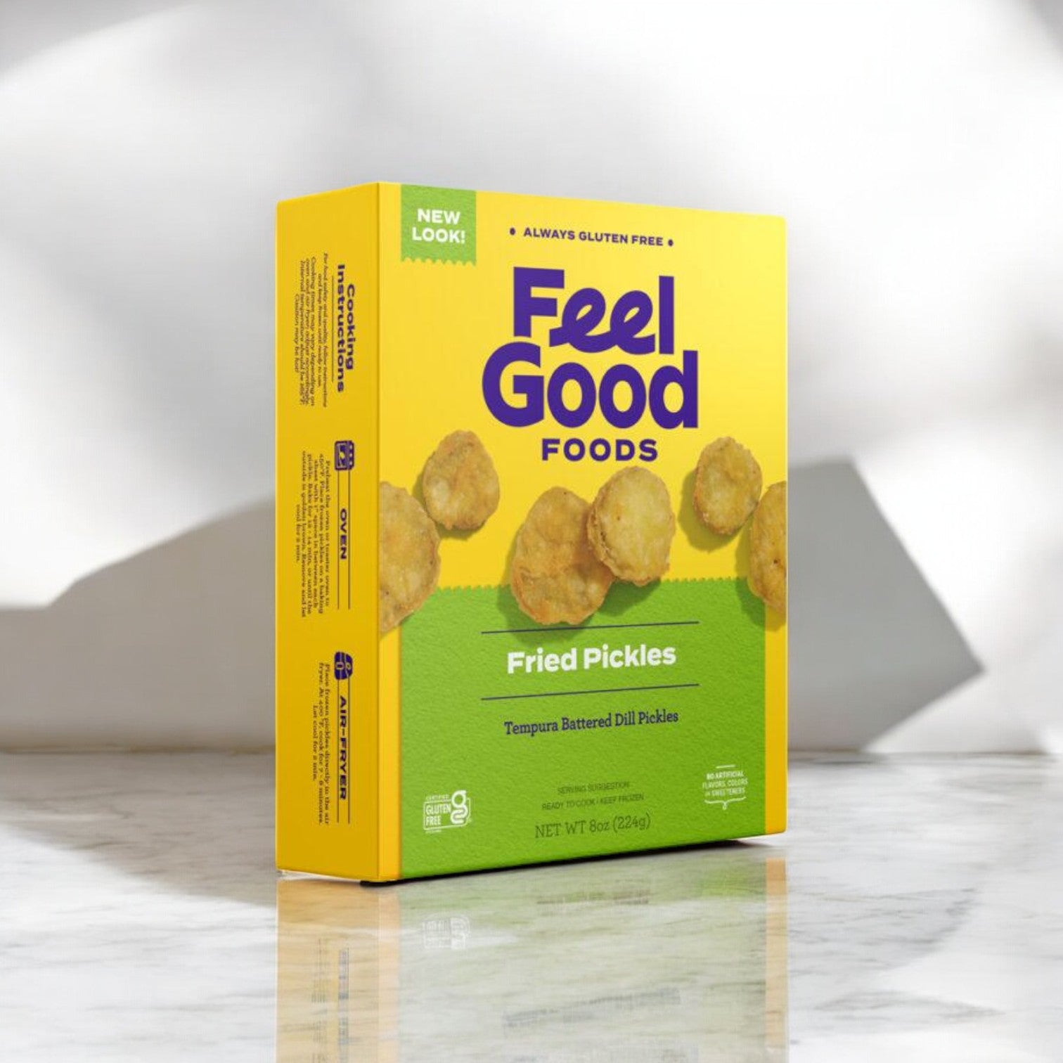 A yellow box labeled "Feel Good Foods Fried Pickles, 8 oz. - 1 Count" rests on a marble surface, containing tempura battered dill pickles. These crunchy snacks are prominently advertised as gluten-free, offering a delightful treat.