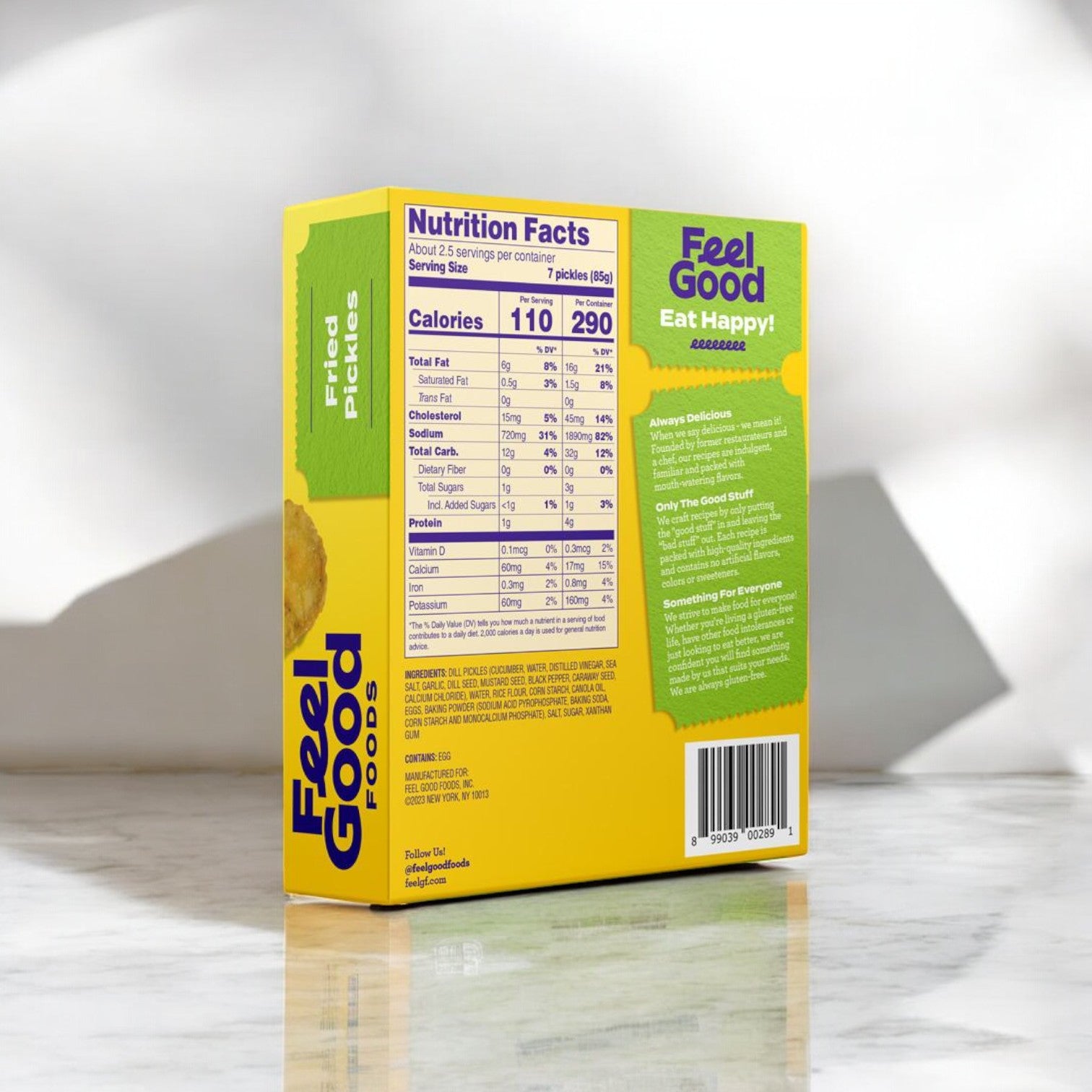 Displayed on a marble surface is a box of Feel Good Foods Fried Pickles, 8 oz., highlighting its nutrition facts and branding on the back. This crunchy snack is ideal for anyone looking for a delicious gluten-free option.