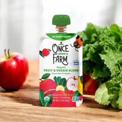 A 3.2 oz pouch of "Once Upon a Farm" Green Kale and Apple blend, displayed alongside fresh apples and kale. The packaging highlights flavors of green kale and apples, with a prominent "No Added Sugar" label, making it ideal for a children's diet that prioritizes non-GMO ingredients.