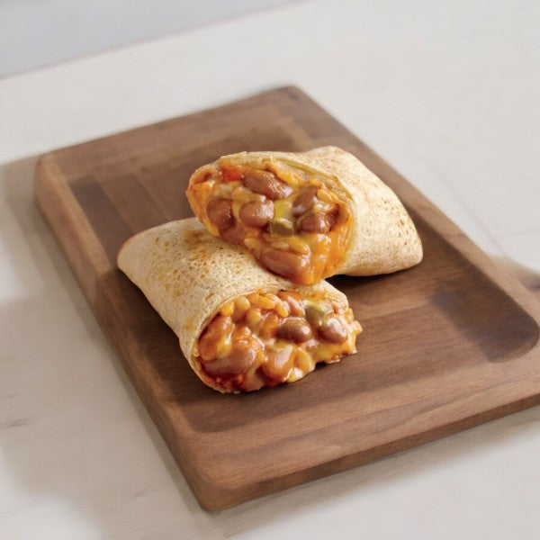 A burrito cut in half, revealing a filling of beans, cheese, and vegetables made from organic ingredients from Amy's Gluten Free Bean & Cheese Frozen Burrito-1 Count by Amy's, placed on a wooden cutting board.