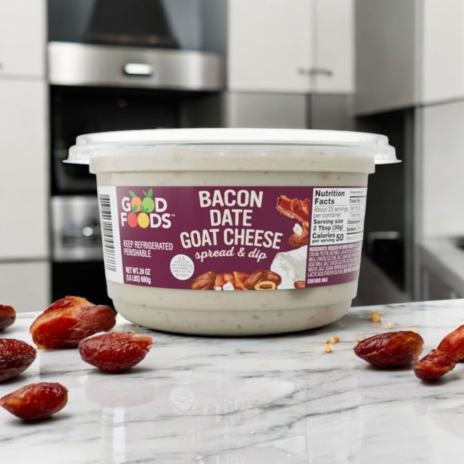 A 24 oz container of Good Foods Bacon & Date Goat Cheese Dip is placed on a marble countertop, surrounded by halved dates, made with natural ingredients for an authentic taste experience.