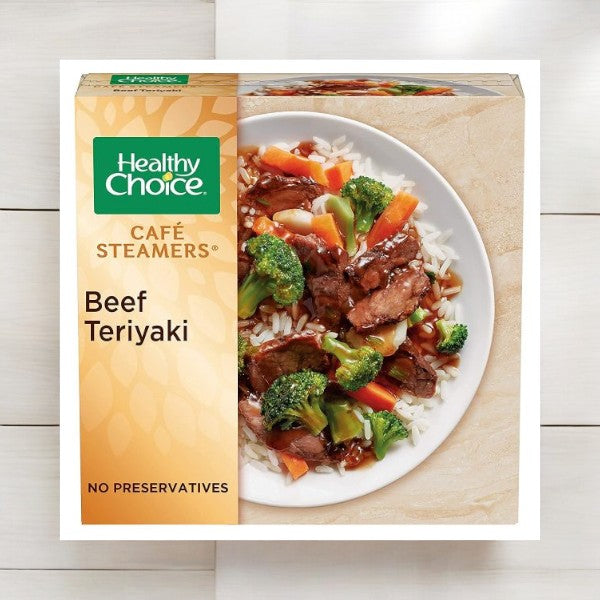 A boxed Healthy Choice Café Steamers Beef Teriyaki meal is featured, showcasing beef, rice, broccoli, carrots, and sauce. The packaging highlights that it contains "No Preservatives." Ideal for quick lunches or dinners, this nutritious meal is included in the Healthy Choice Meals Bundle - 8 Meal Bundle from Healthy Choice.