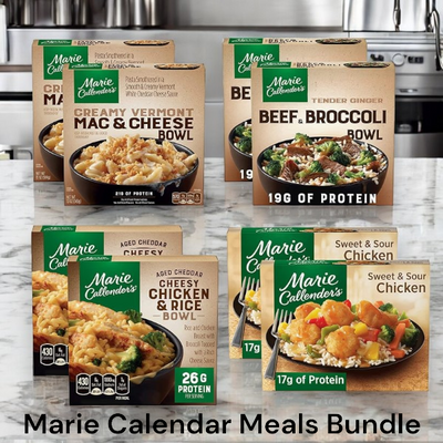 A variety of Marie Callender's frozen meals, including mac & cheese, the Aged Cheddar Cheesy Chicken & Rice Bowl, and sweet & sour chicken are displayed on a kitchen counter. Text: "Marie Callender's Meals Bundle- 2 Chicken and Rice, 2 Beef and Broccoli, 2 Mac and Cheese, and Sweet and Sour Chicken- 8 Total Meals.