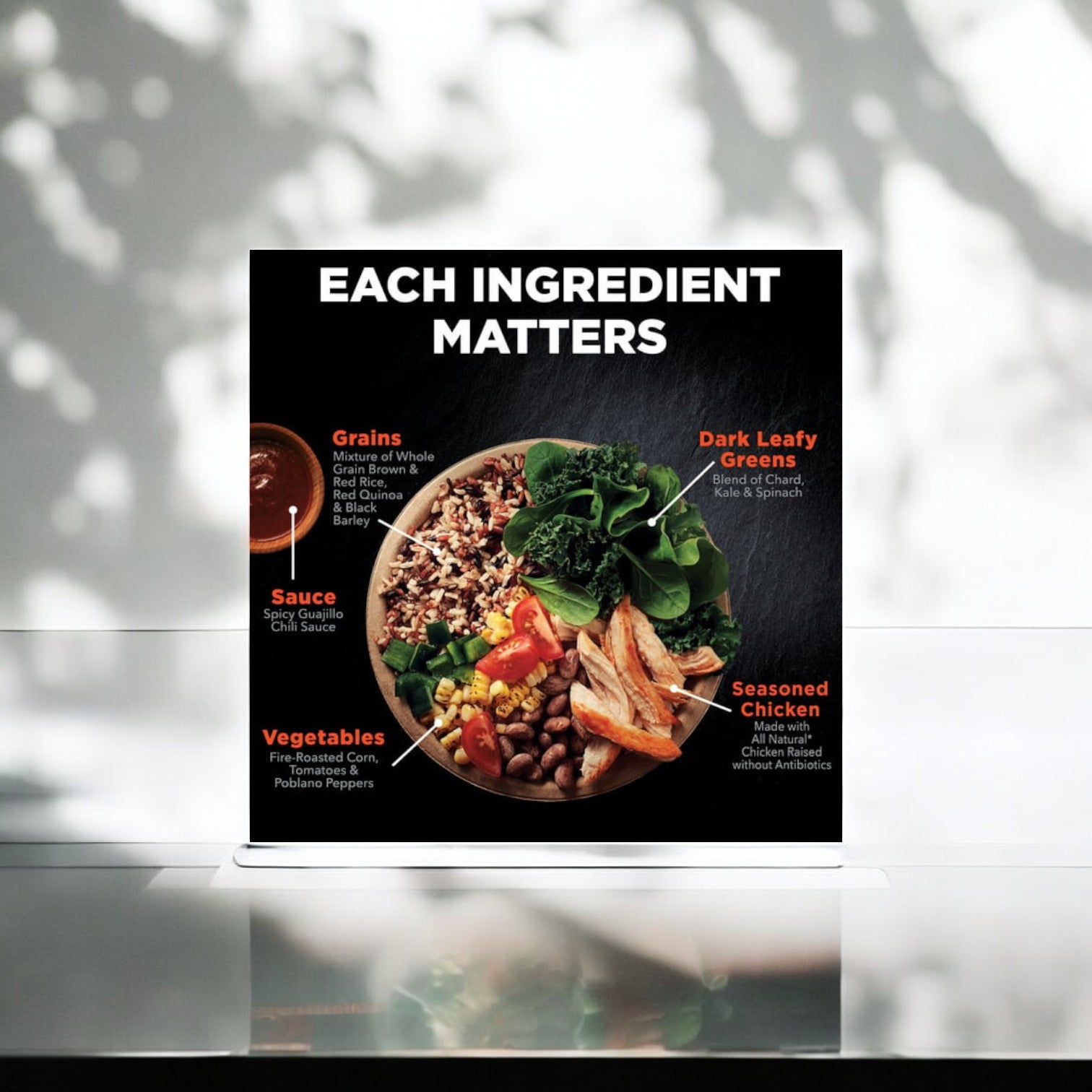 A poster featuring a Healthy Choice Power Bowls Chicken Adobo, 9.75 oz. - 1 Count, showcasing its nutritious ingredients: grains, dark leafy greens, sauce, vegetables, and seasoned Chicken Adobo with the header "EACH INGREDIENT MATTERS.