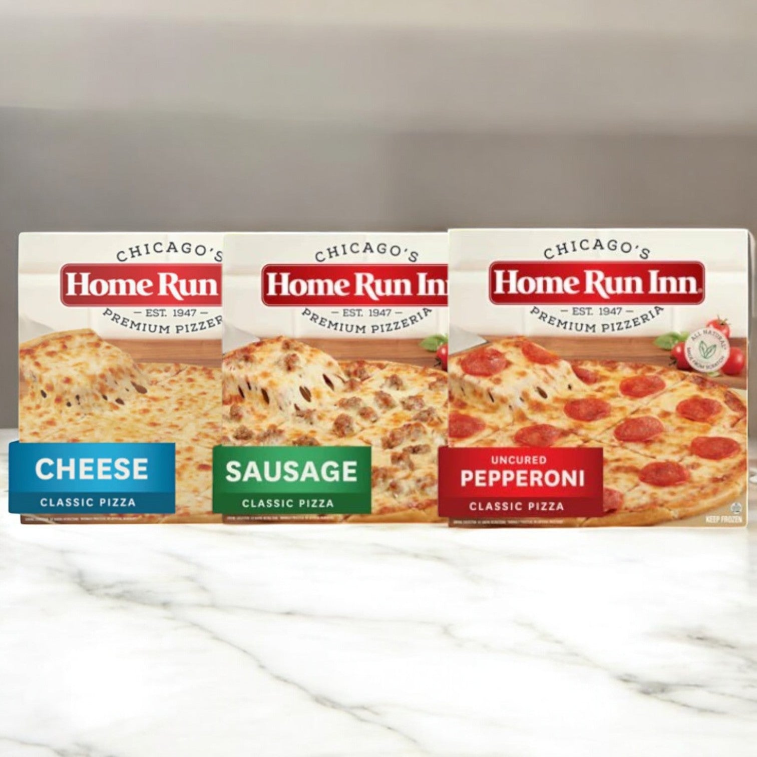 On a marble surface, find Home Run Inn's 6-Pack Pizza Combo—three family-sized and three single-serve pizzas, including cheese, sausage, and uncured pepperoni varieties—ideal for family pizza nights.