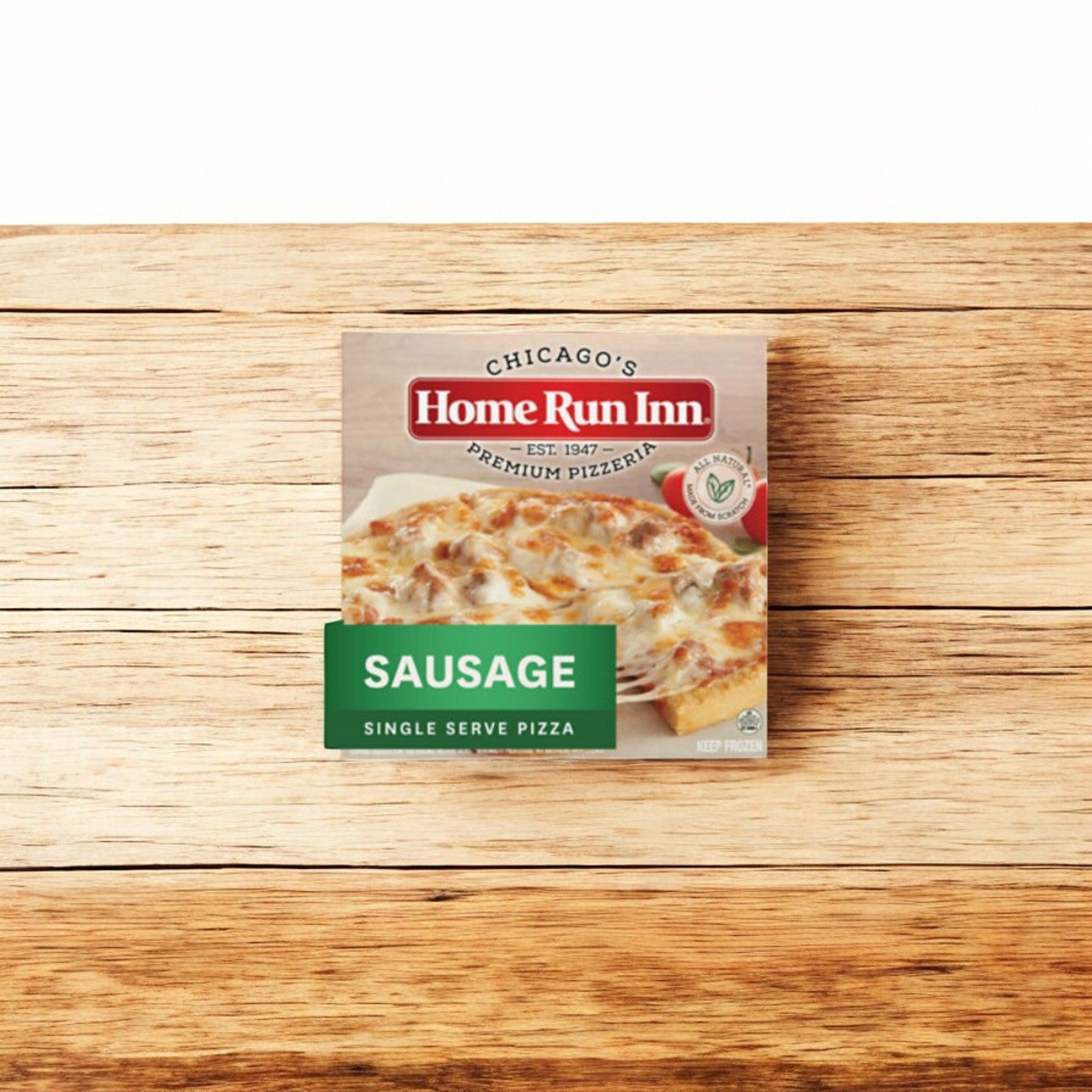 The Home Run Inn Mini Personal Pizza, Classic Frozen Sausage Pizza, 8.5 oz. - 1 Count sits on a wooden surface, offering the perfect personal frozen pizza with a delicious sausage topping.