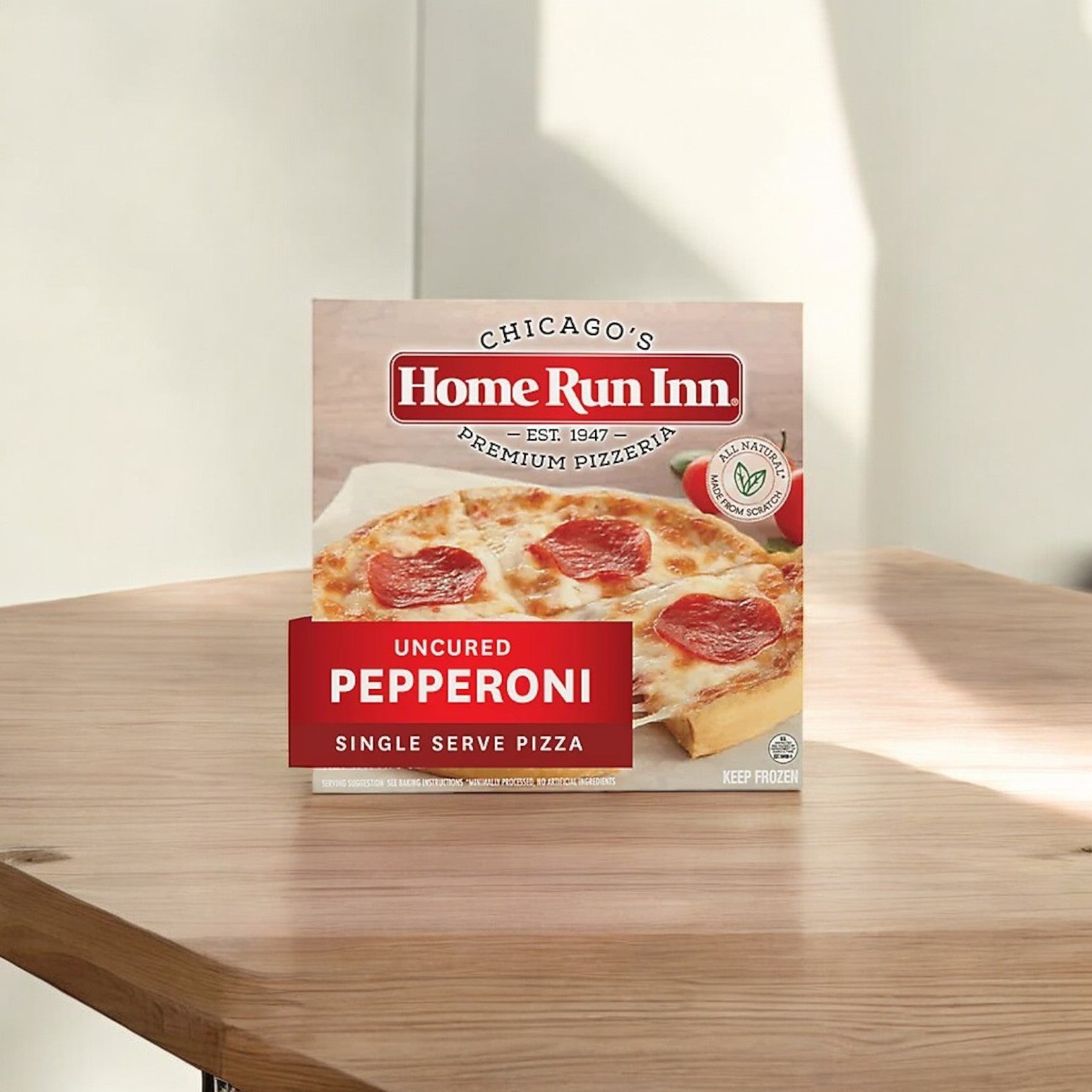 A box of Home Run Inn Classic Crust Frozen Pizza Uncured Pepperoni, 7.75 oz.,  sits on a wooden table.