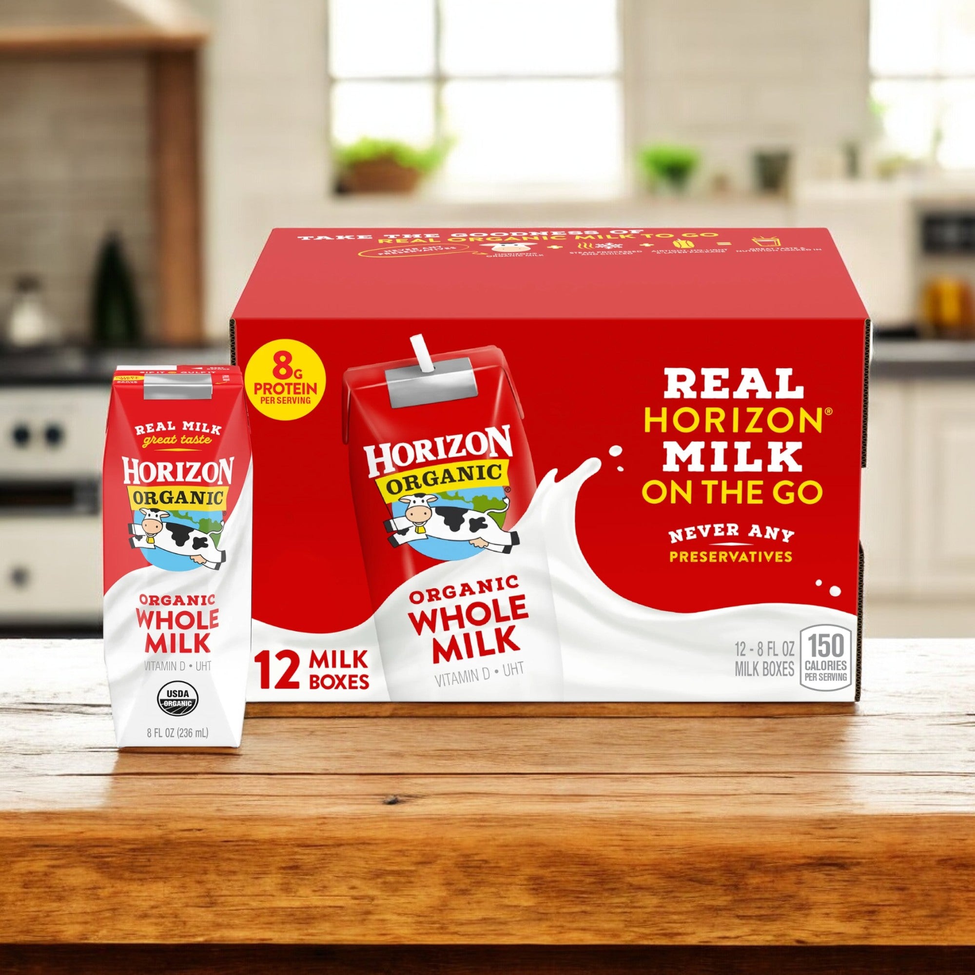 A 24-pack of Easy Lunches Organic Horizon Whole Milk & Chocolate Milk cartons is displayed on a kitchen counter, featuring individual 8 fl oz boxes. The packaging advertises organic milk with 8 grams of protein and no preservatives.