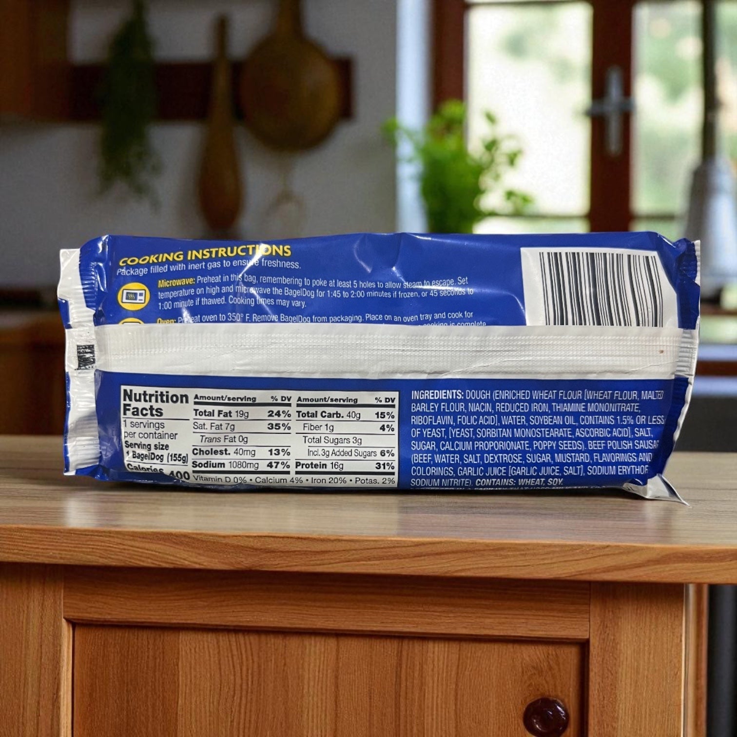 A package of Vienna Beef Polish Sausage Bagel Dog sits on a wooden kitchen counter with a blurred kitchen background, displaying nutrition facts, ingredients, and cooking instructions—just like other Vienna Beef products.