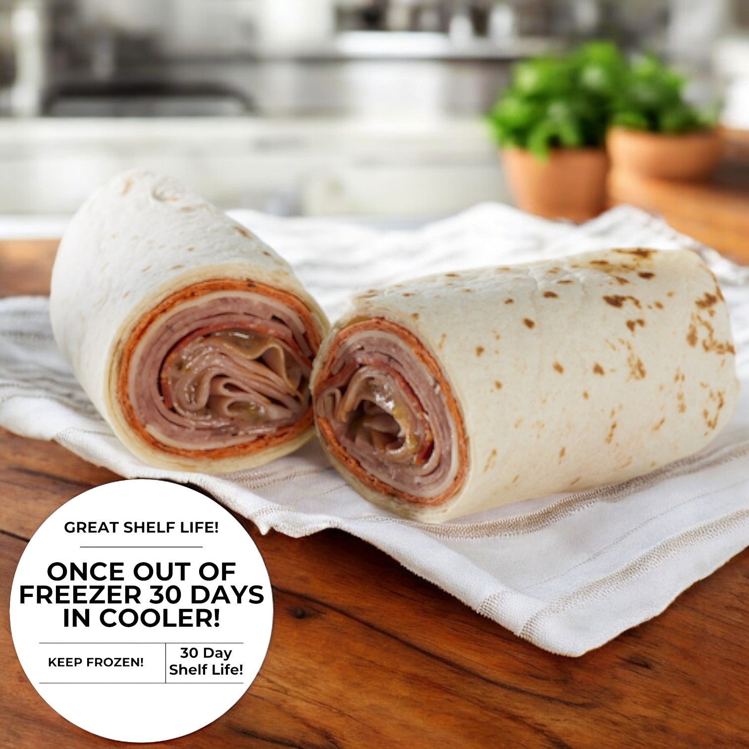 A pair of Italian Style Wraps from E.A. Sween, filled with deli meat, perhaps prosciutto, are set on a cloth napkin. A label emphasizes their 30-day shelf life when stored outside the freezer, adding a touch of convenience to these delectable samples of genuine Italian cuisine.