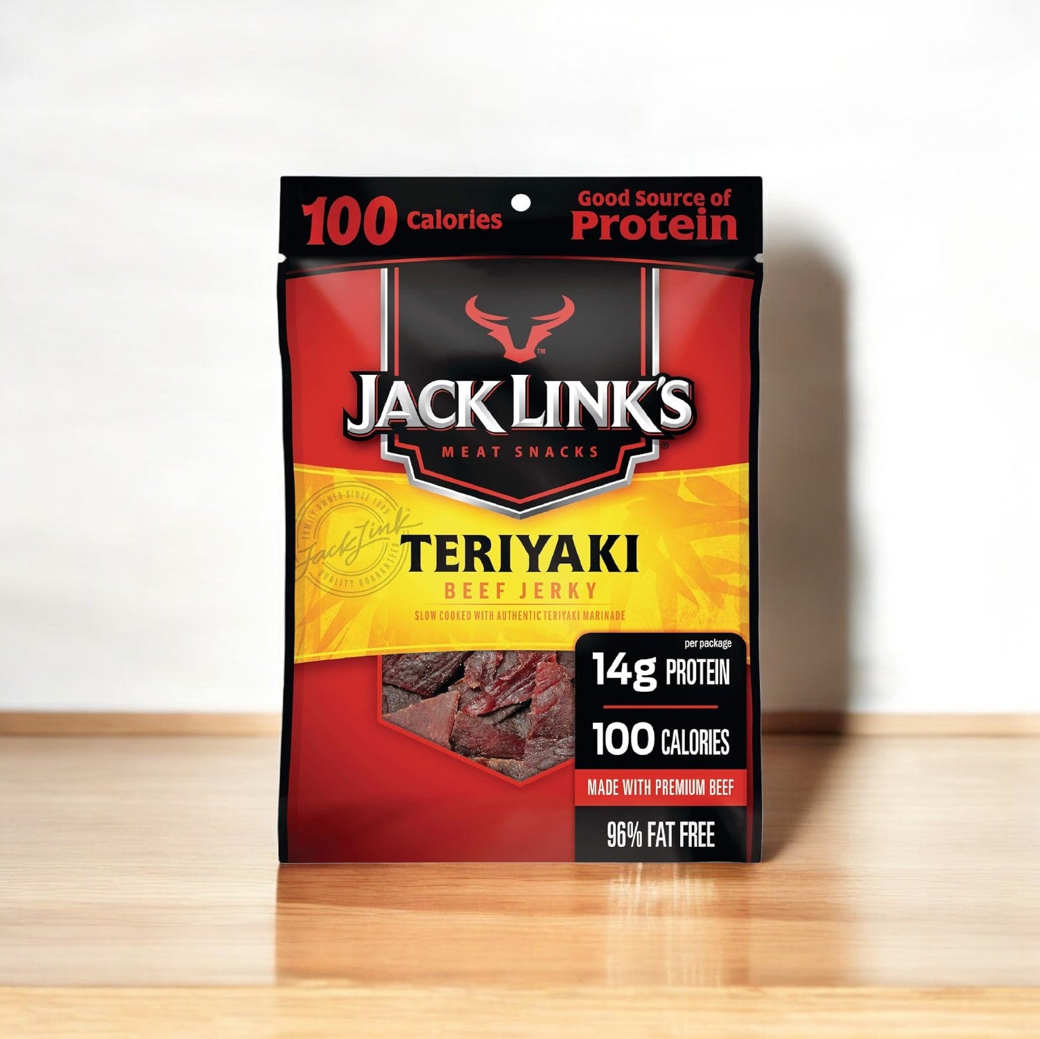 A package of Jack Link's Beef Jerky, Teriyaki (1.25 oz, 1 Count), is placed on a wooden surface. The packaging highlights 14g of protein and 100 calories per serving, emphasizing that the jerky is made with premium beef. Perfect for those seeking high-quality single-serve packages from Jack Link's.