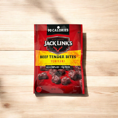 A red package of Jack Link's Beef Tender Bites Teriyaki on a wooden surface, labeled with 90 calories and containing 1.25 oz of delicious meat snacks. Perfect for anyone seeking a tasty and convenient snack option from the Jack Link's variety pack.