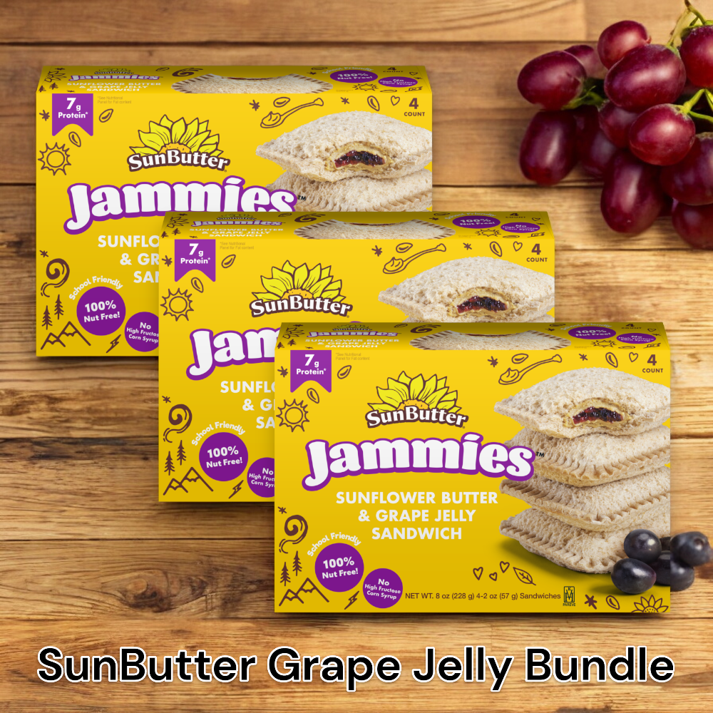 Three boxes of Easy Lunches SunButter Jammies Sandwiches, Sunflower Butter & Grape Jelly - a total of 12 sandwiches - are on a wooden surface next to a bunch of red grapes. Text at the bottom reads "SunButter Grape Jelly Bundle.