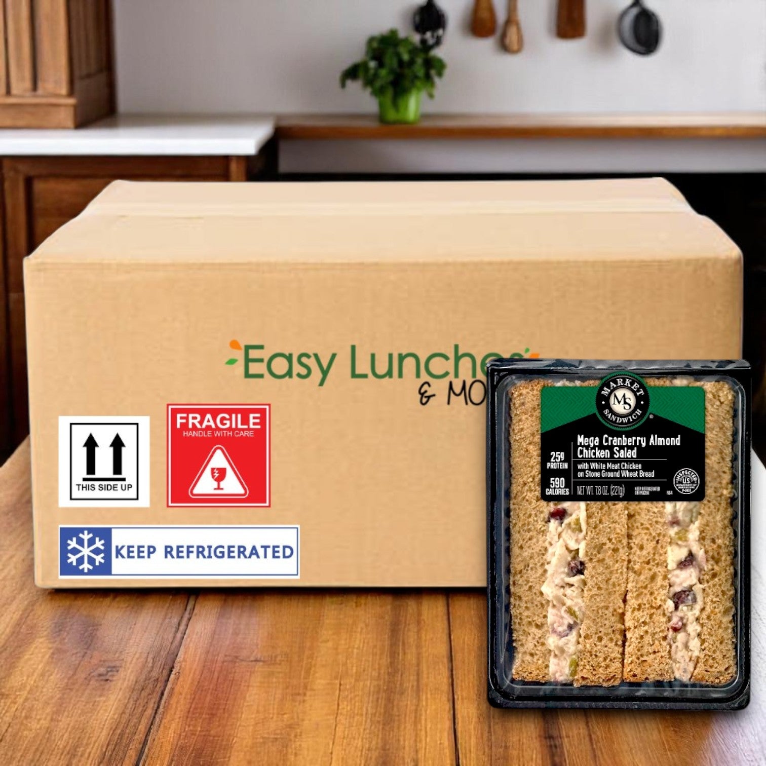 A Market Sandwich Mega Cranberry Almond Chicken Salad on Stone Ground Wheat Bread (7.8 oz, E.A. Sween) is individually wrapped in front of a labeled shipping box with handling stickers, with 8 sandwiches per case.