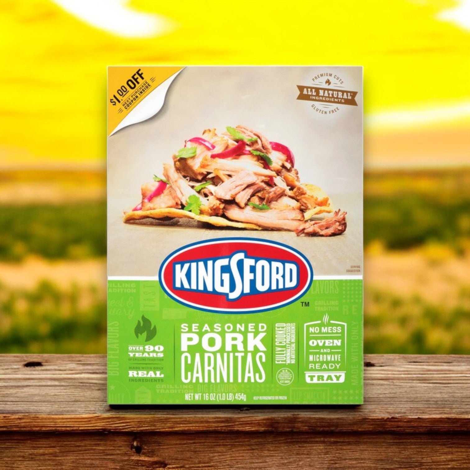 Kingsford Seasoned Pork Carnitas – 16 oz -3 Count box on a wooden surface features slow-cooked pork with onions and peppers on taco shells, highlighting all-natural ingredients, smoky seasoning, and microwave readiness.