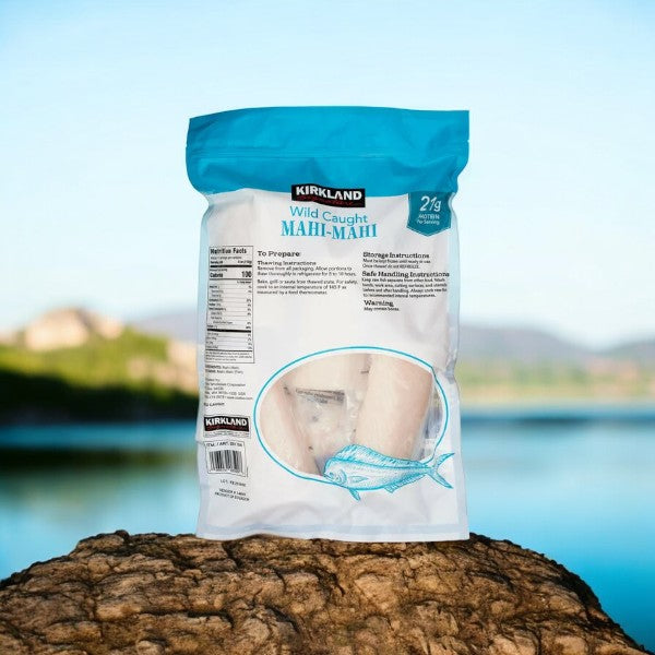 A bag of Kirkland Signature Wild Pacific Mahi-Mahi, a lean protein source, is placed on a rock with a blurred outdoor background.