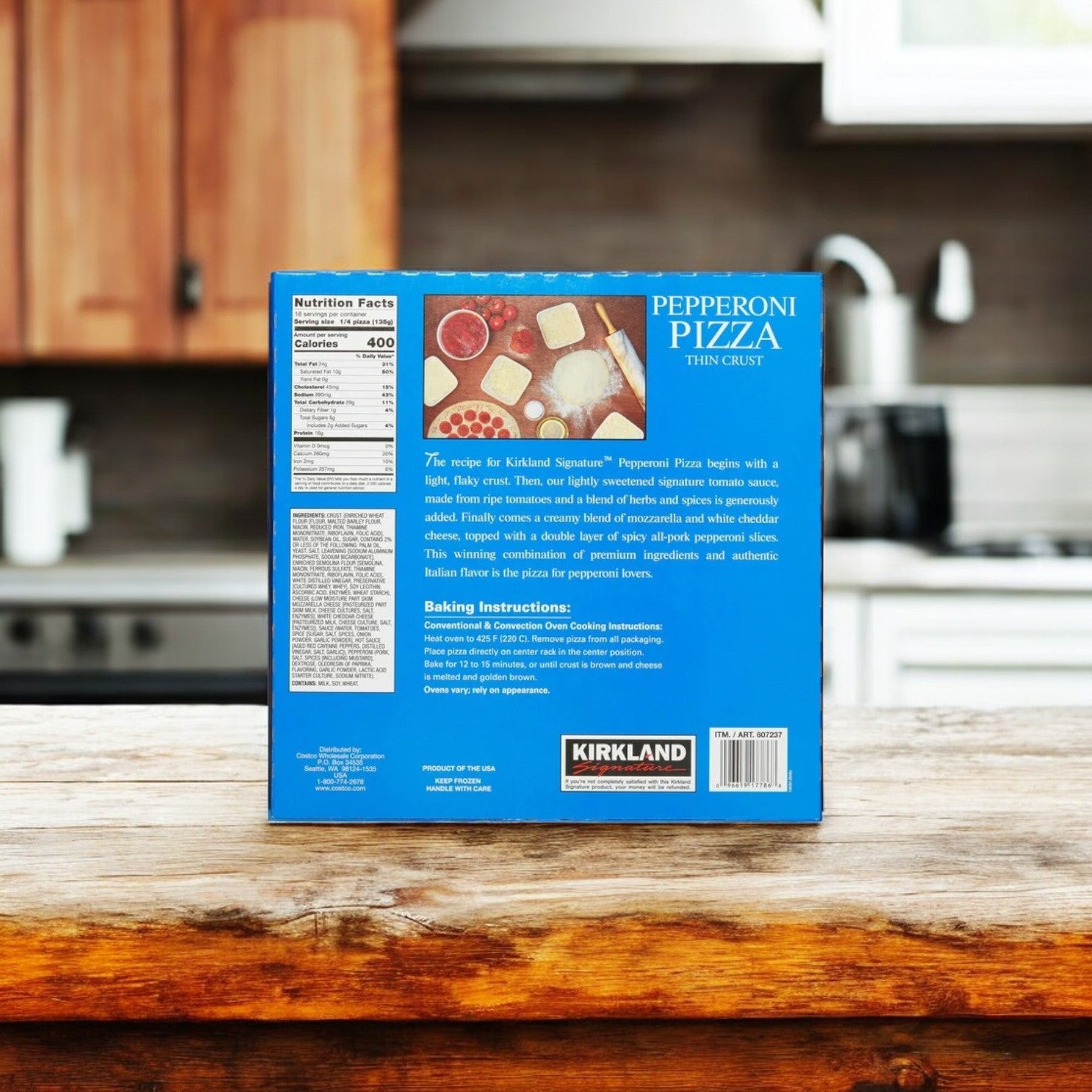 A box of Kirkland Signature Pepperoni Pizza, 19.05 oz, 4-count - 3 Pack rests on a wooden kitchen counter. This pizza showcases melted mozzarella cheese and a crispy crust, with the packaging providing nutrition facts, baking instructions, and a product description.