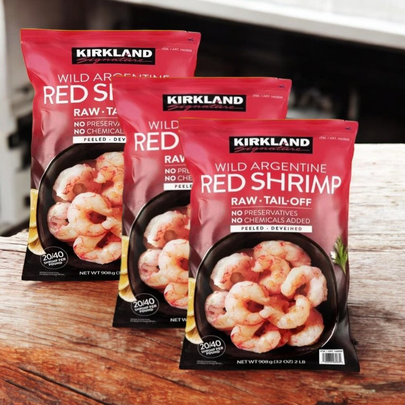 Three bags of Easy Lunches Kirkland Signature Wild Argentine Raw Shrimp (20/40 count, 2 lbs per bag, 6 lbs total) are displayed on a wooden surface.